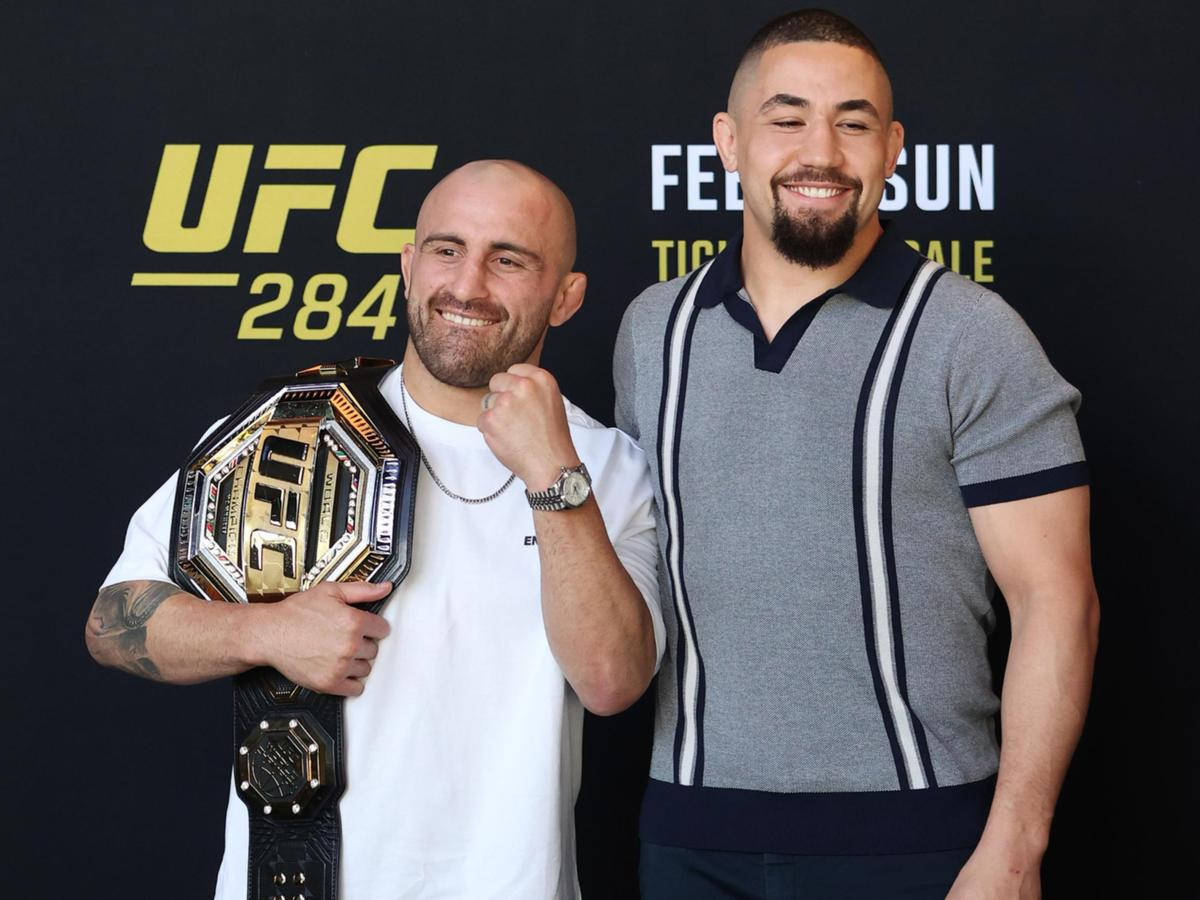 UFC 桌布 壁紙 — 兩位微笑的UFC拳手在黑色背景前與冠軍腰帶合影，背景上有UFC 284標誌。