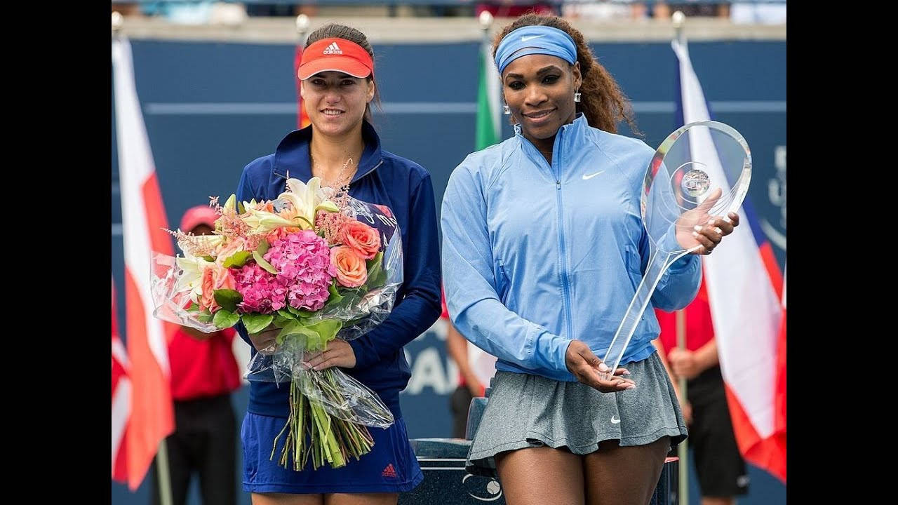 運動 桌布 壁紙 — 兩位微笑的女網球選手在球場上擺姿勢，一位拿著獎盃，另一位拿著一束粉紅色和橙色的花。