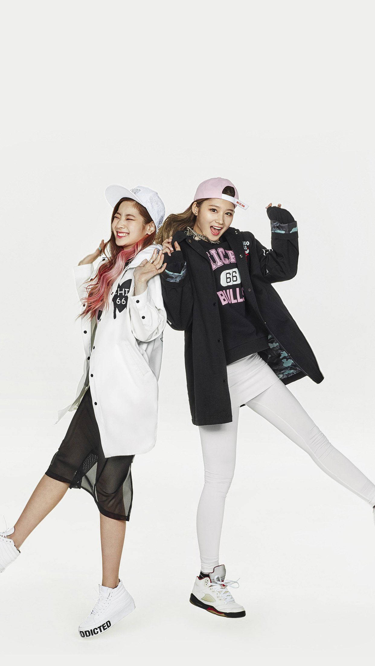 twice 桌布 壁紙 — 兩位微笑的年輕女性穿著時尚街頭服飾，在純白背景前擺出俏皮姿勢。