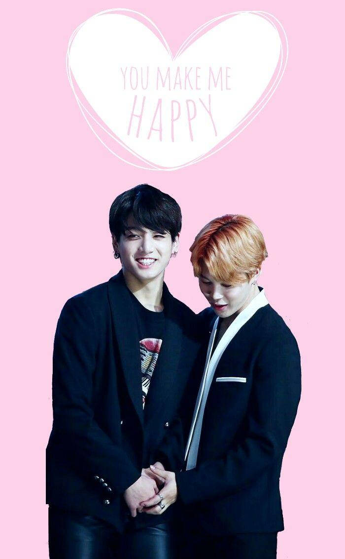 Jikook 桌布 壁紙 — 兩位微笑的年輕男士身穿黑色西裝，在粉紅色背景前手牽手，還有一個寫著「you make me happy」的心形圖案。
