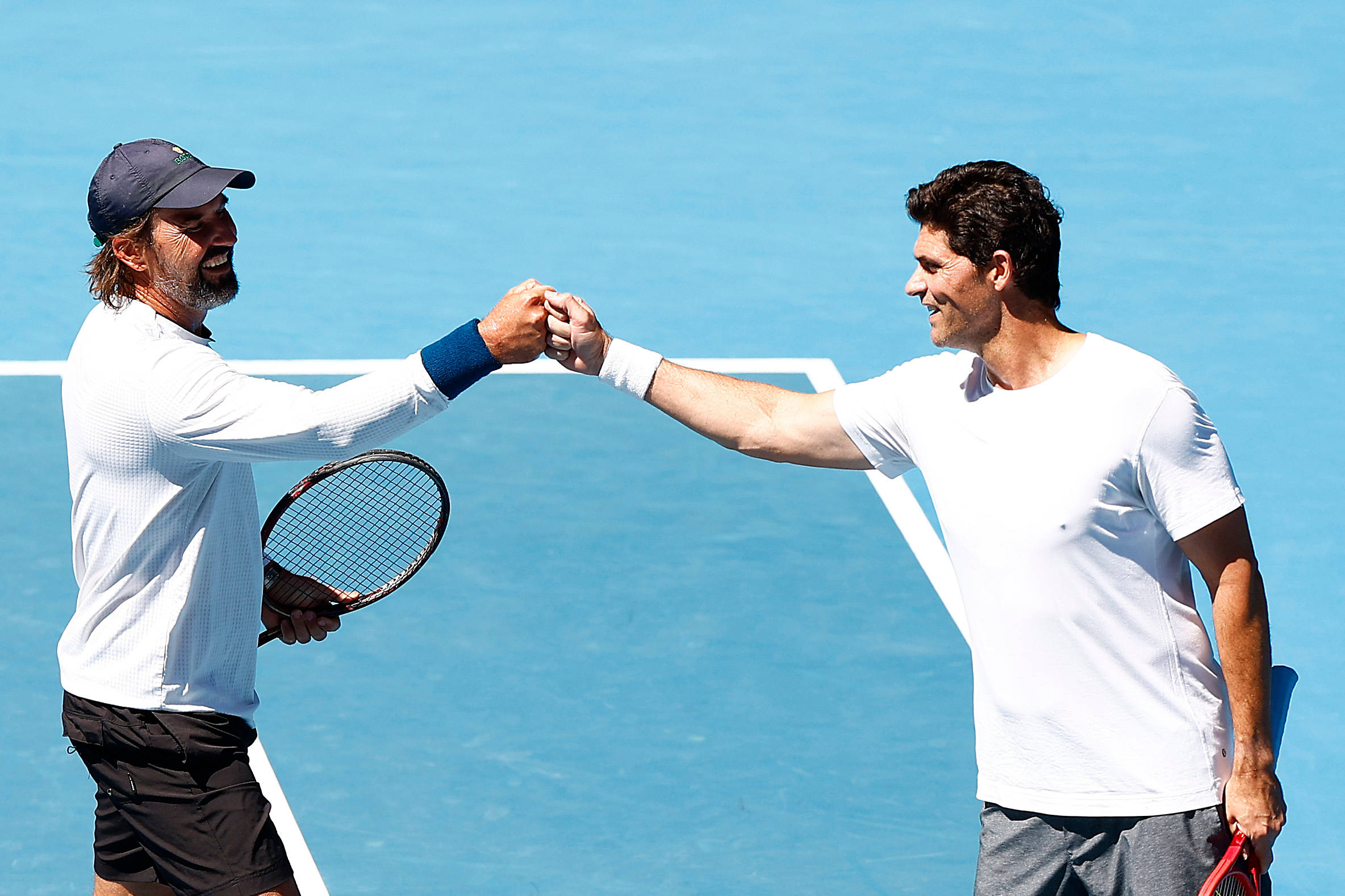 運動 桌布 壁紙 — 兩位微笑的男性網球運動員在明亮的藍色球場上，在晴朗的日光下握手。