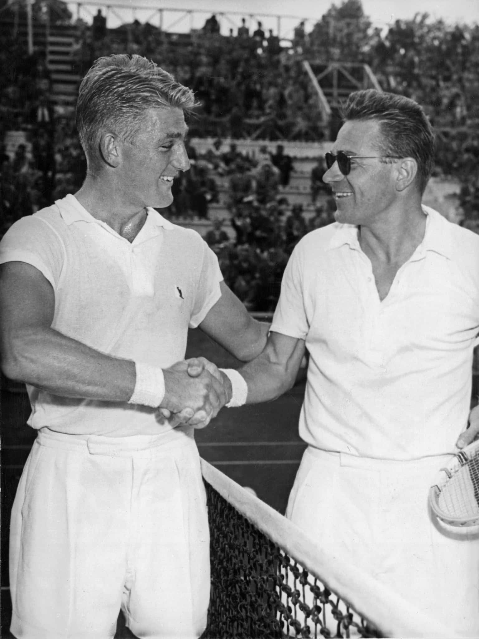 Tennis 桌布 壁紙 — 兩位微笑的網球選手隔網握手，背景有觀眾。