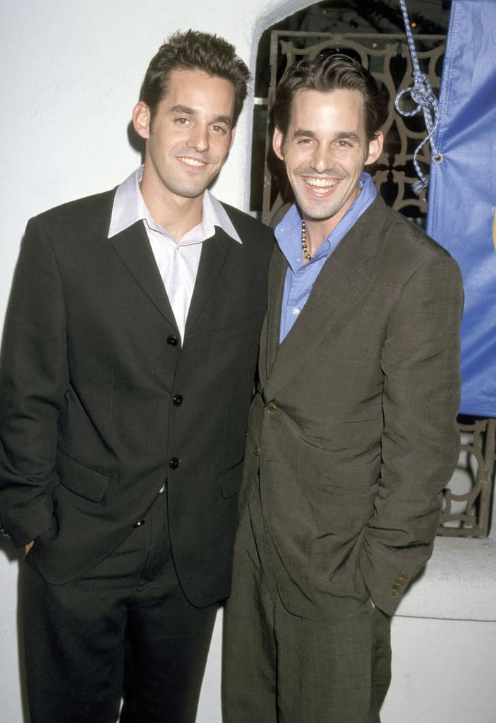 Nicholas Brendon 桌布 壁紙 — 兩位微笑的西裝男一起擺姿勢，手插口袋，背景是白色牆壁和藍色背景。