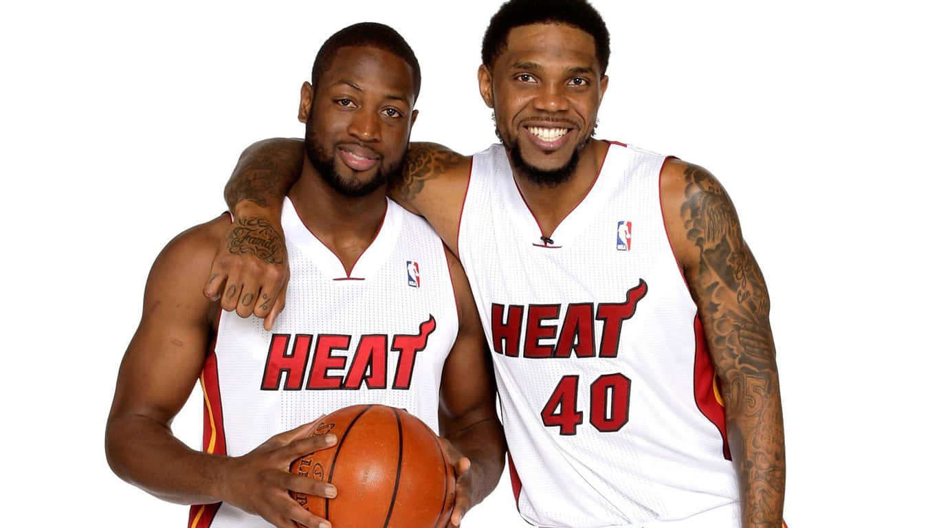 Udonis Haslem 桌布 壁紙 — 兩位微笑的邁阿密熱火籃球運動員一起擺姿勢，其中一位在純白色背景前拿著球。