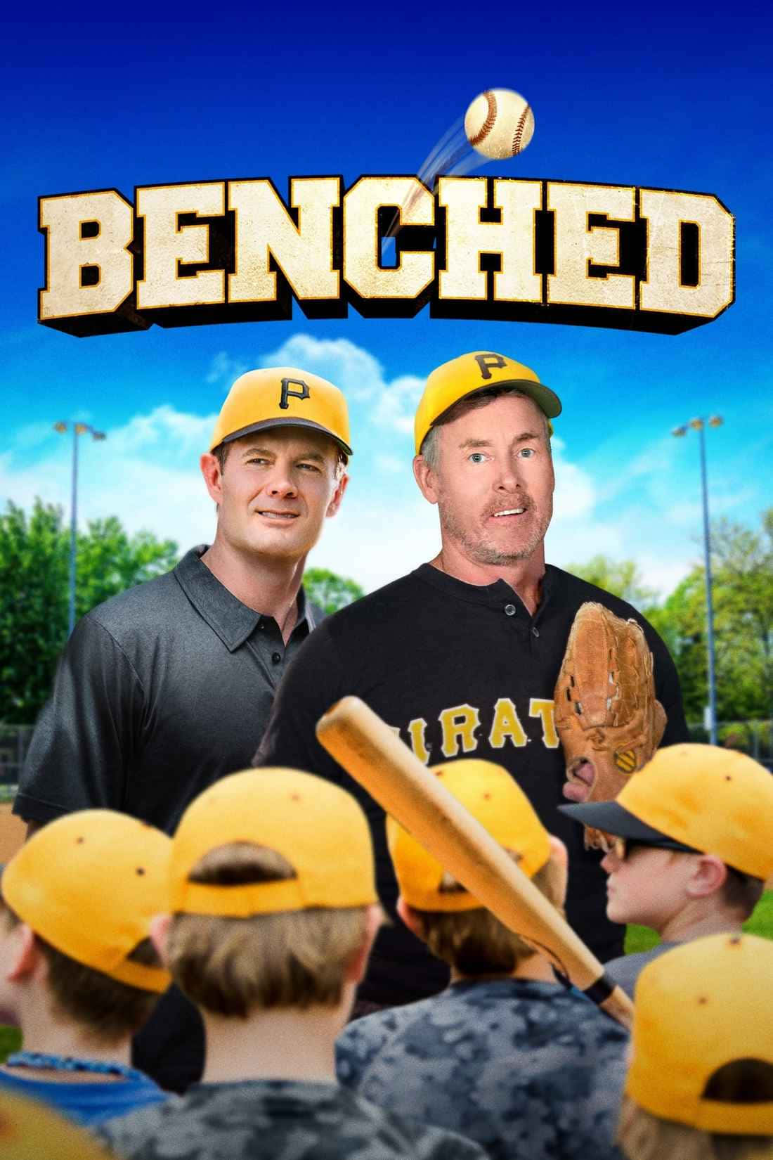 John C. Mcginley 桌布 壁紙 — 兩位戴黃色帽子的棒球教練站在年輕球員面前，在晴朗的藍天下，陽光明媚的球場上，他們上方有粗體字 'BENCHED'。