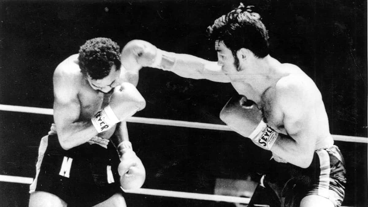 boxer 桌布 壁紙 — 兩位拳擊手在 gritty 黑白擂台上交鋒，一人出拳，另一人低身閃避。