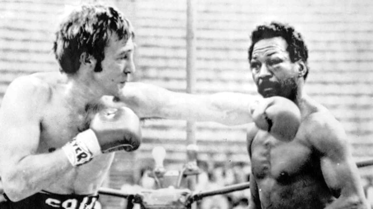 boxer 桌布 壁紙 — 兩位拳擊手在粗糙的黑白擂台上交鋒，其中一人向對方的臉部揮拳。