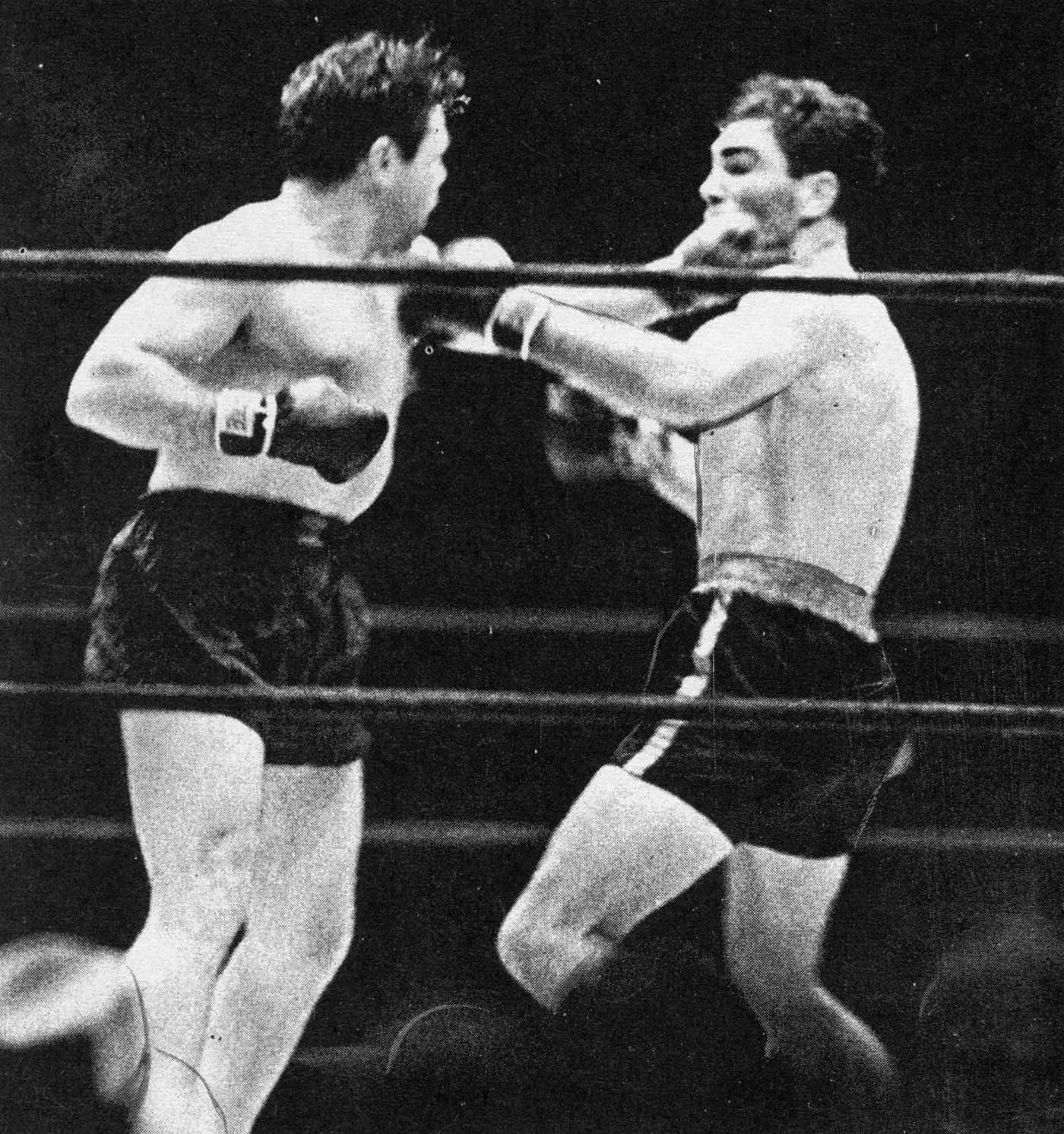 boxer 桌布 壁紙 — 兩位拳擊手在粗糙的黑白擂台上交鋒，其中一人揮出一拳，繩索框住了這緊張的時刻。