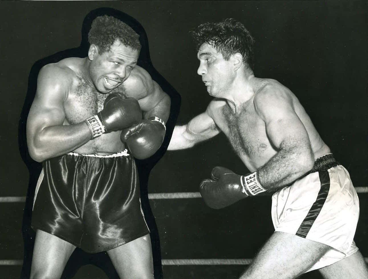 Boxing 桌布 壁紙 — 兩位拳擊手在粗糙的黑白擂台鏡頭中碰撞，一人向前猛衝，另一人則準備迎接衝擊。