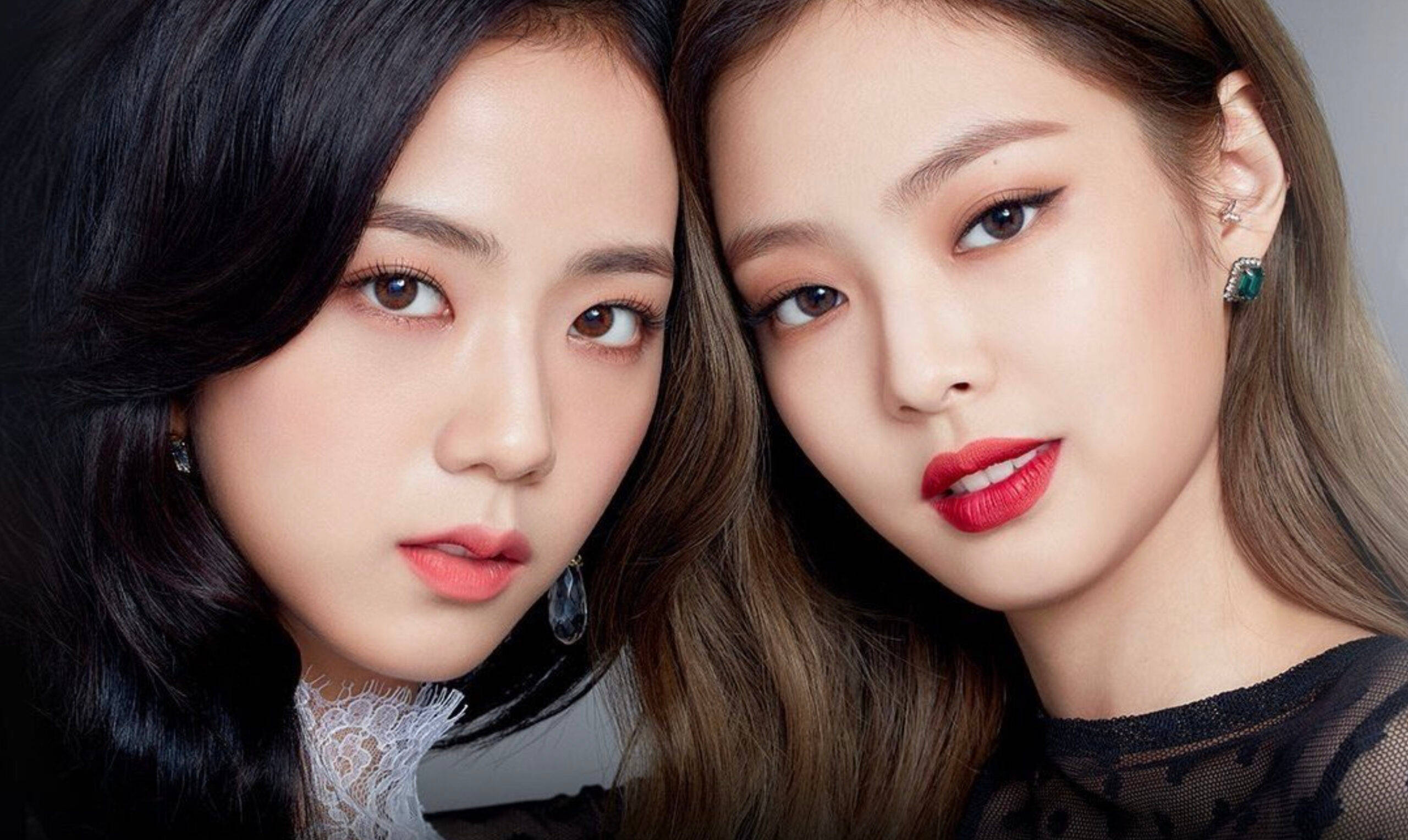 jisoo 可愛 桌布 壁紙 — 兩位擁有完美妝容和優雅珠寶的女性在柔和燈光下直視鏡頭。