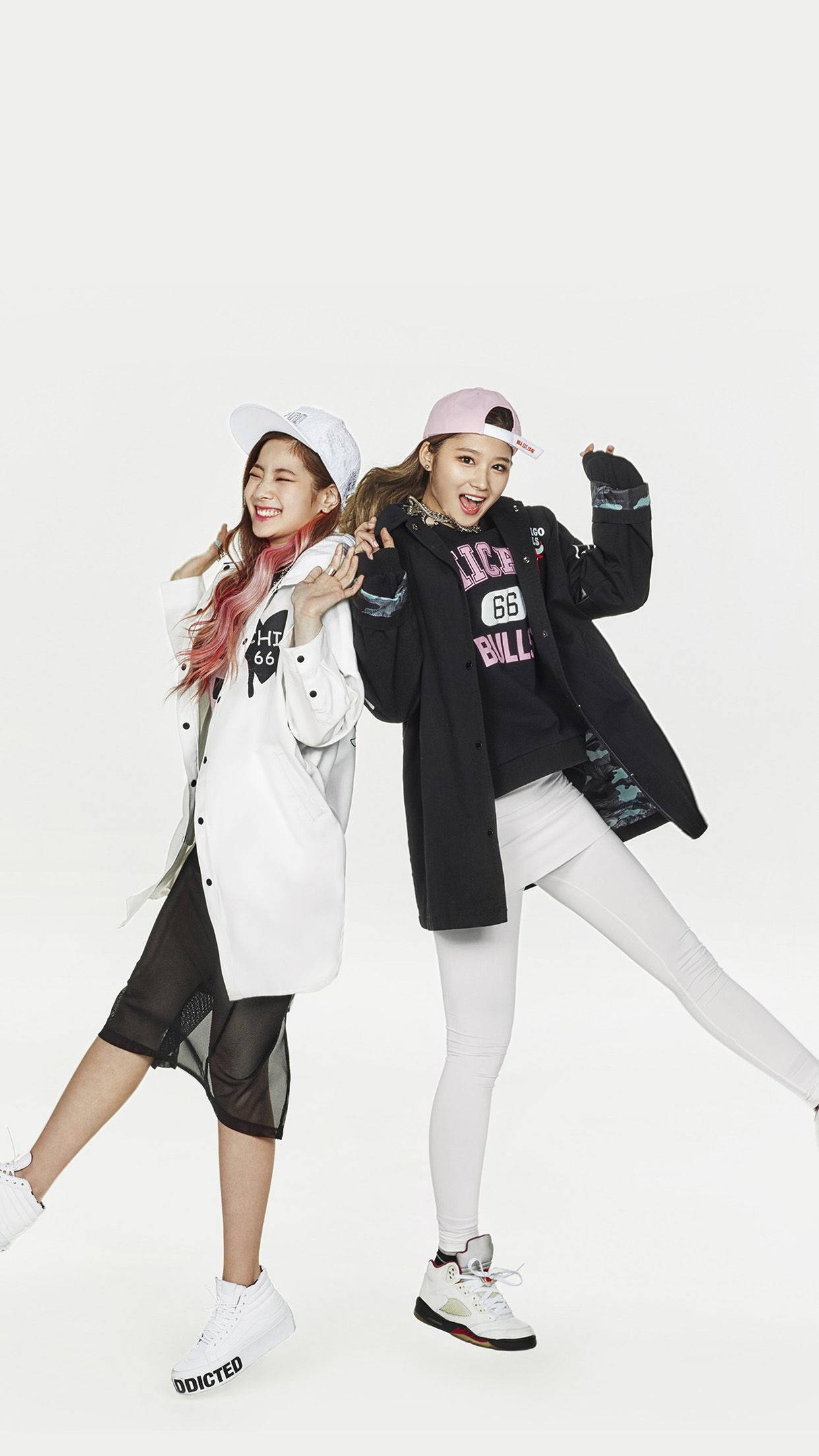 twice 桌布 壁紙 — 兩位時尚年輕女性在純白背景前擺出俏皮姿勢，穿著時尚街頭服飾。