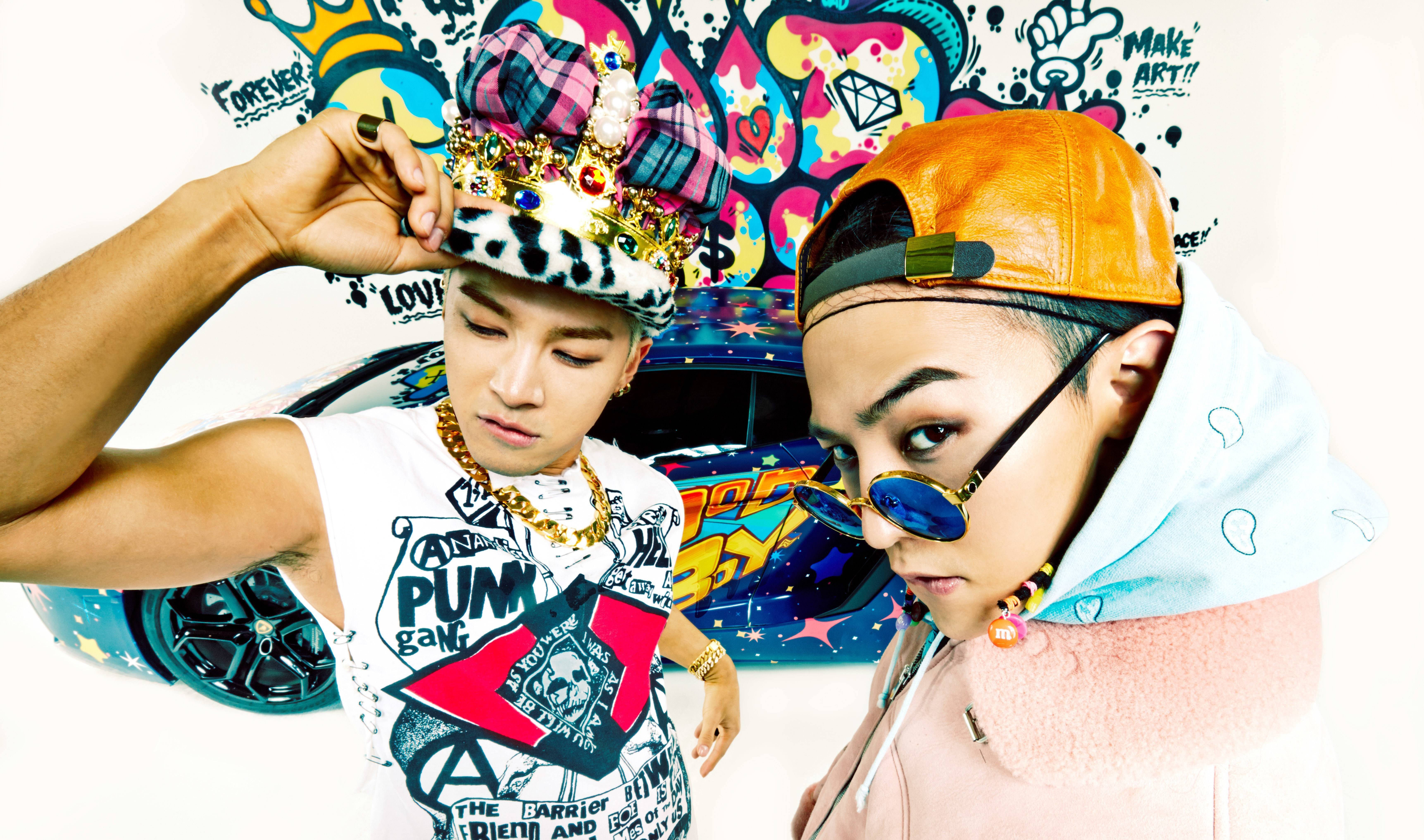 Bigbang 桌布 壁紙 — 兩位時尚打扮的男士自信地在一幅充滿活力的塗鴉牆前擺姿勢，背景是一輛色彩繽紛的汽車。