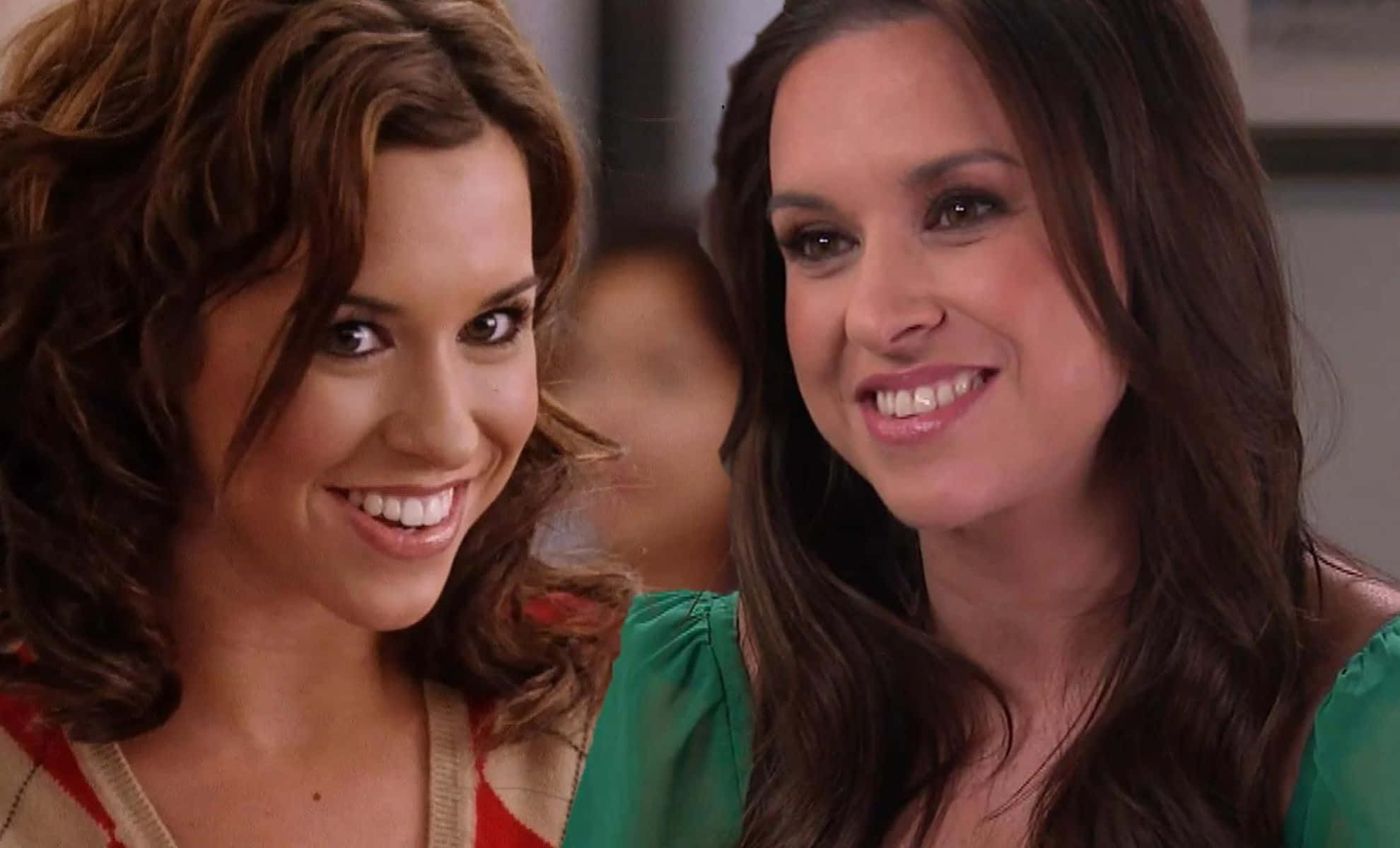 lacey chabert 桌布 壁紙 — 兩位棕色頭髮的女士在溫暖燈光的室內環境中分享歡樂時刻。