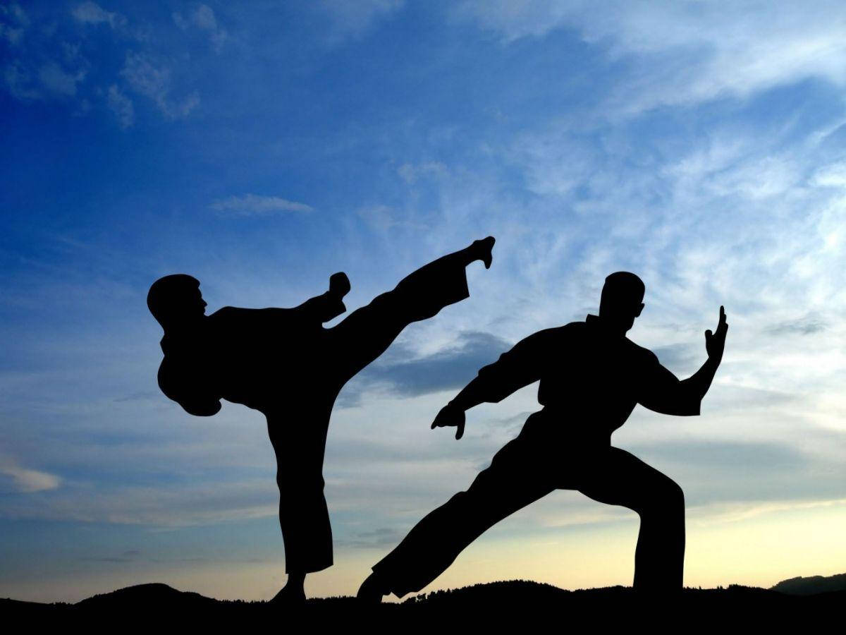 martial arts 桌布 壁紙 — 兩位武術家以剪影形式在暮色天空與戲劇性雲層中決鬥。