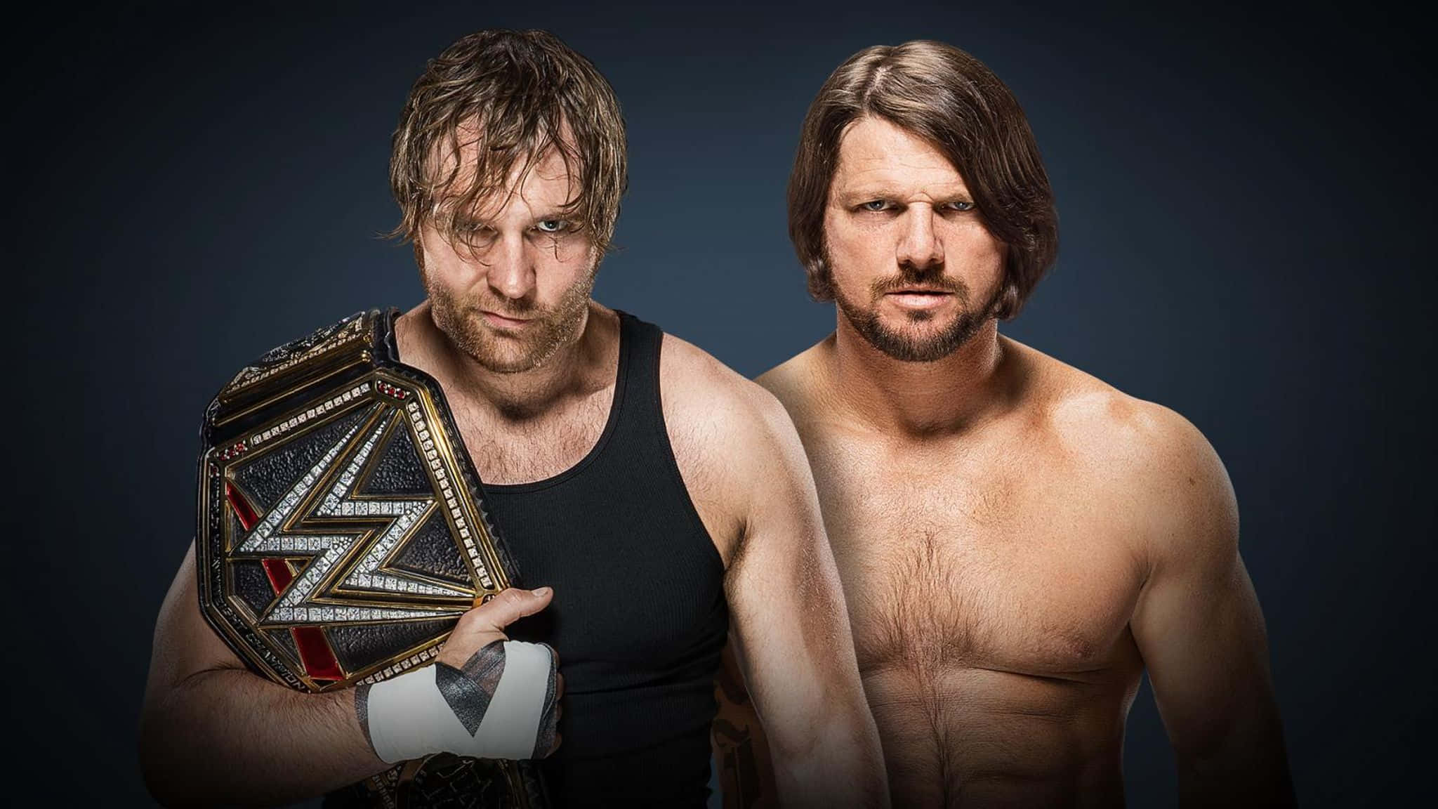 WWE 桌布 壁紙 — 兩位激烈的WWE摔角手向前凝視，其中一人手持冠軍腰帶，背景為黑暗的攝影棚。