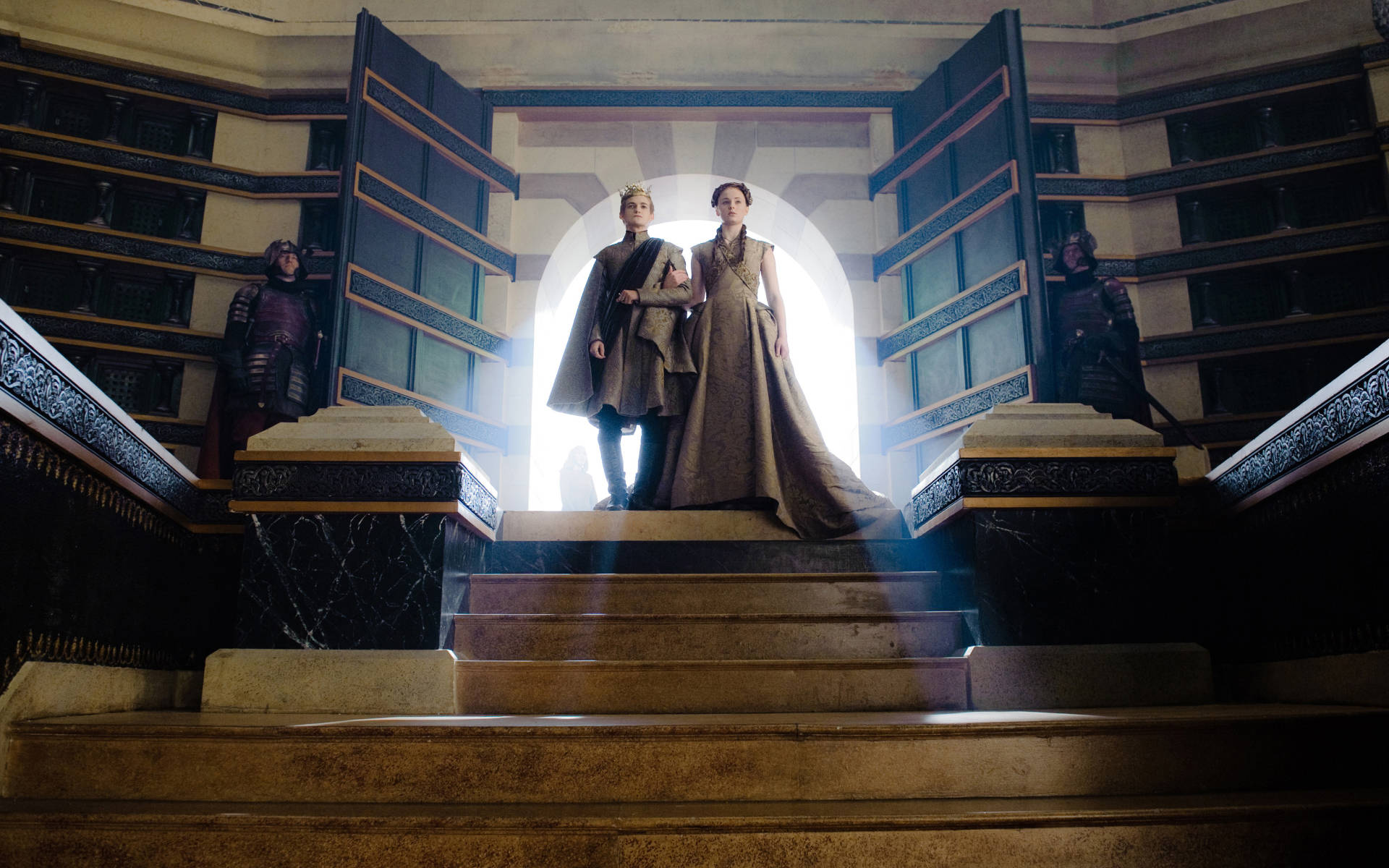 Sansa Stark 桌布 壁紙 — 兩位皇室人物站在宏偉的石階頂端，沐浴在戲劇性的背光中，兩旁是華麗宮殿大廳中的武裝衛兵。