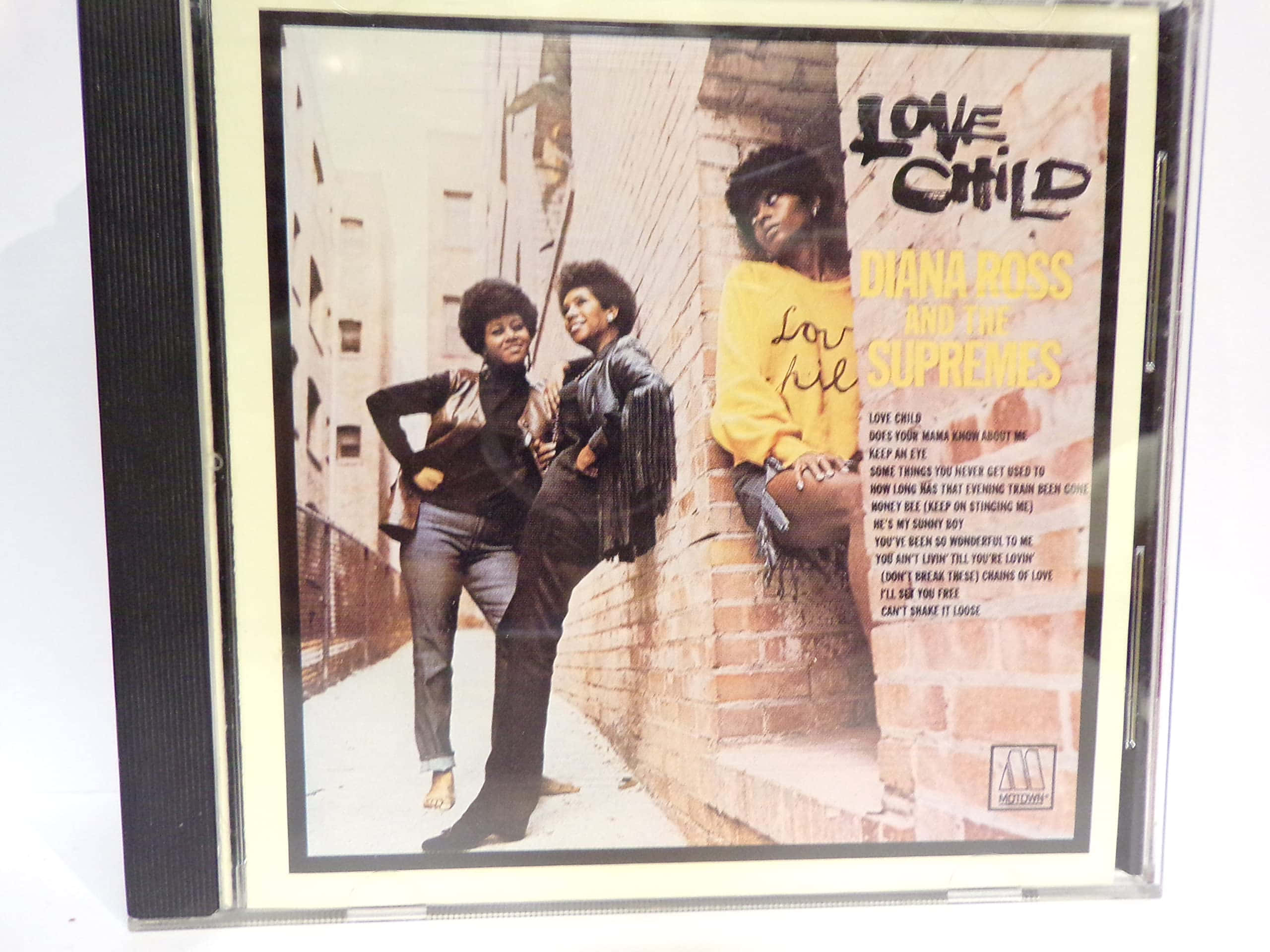 Album Cover 桌布 壁紙 — 兩位穿著1970年代時尚的女性在城市的磚牆前自信地擺姿勢，並以CD盒框住。