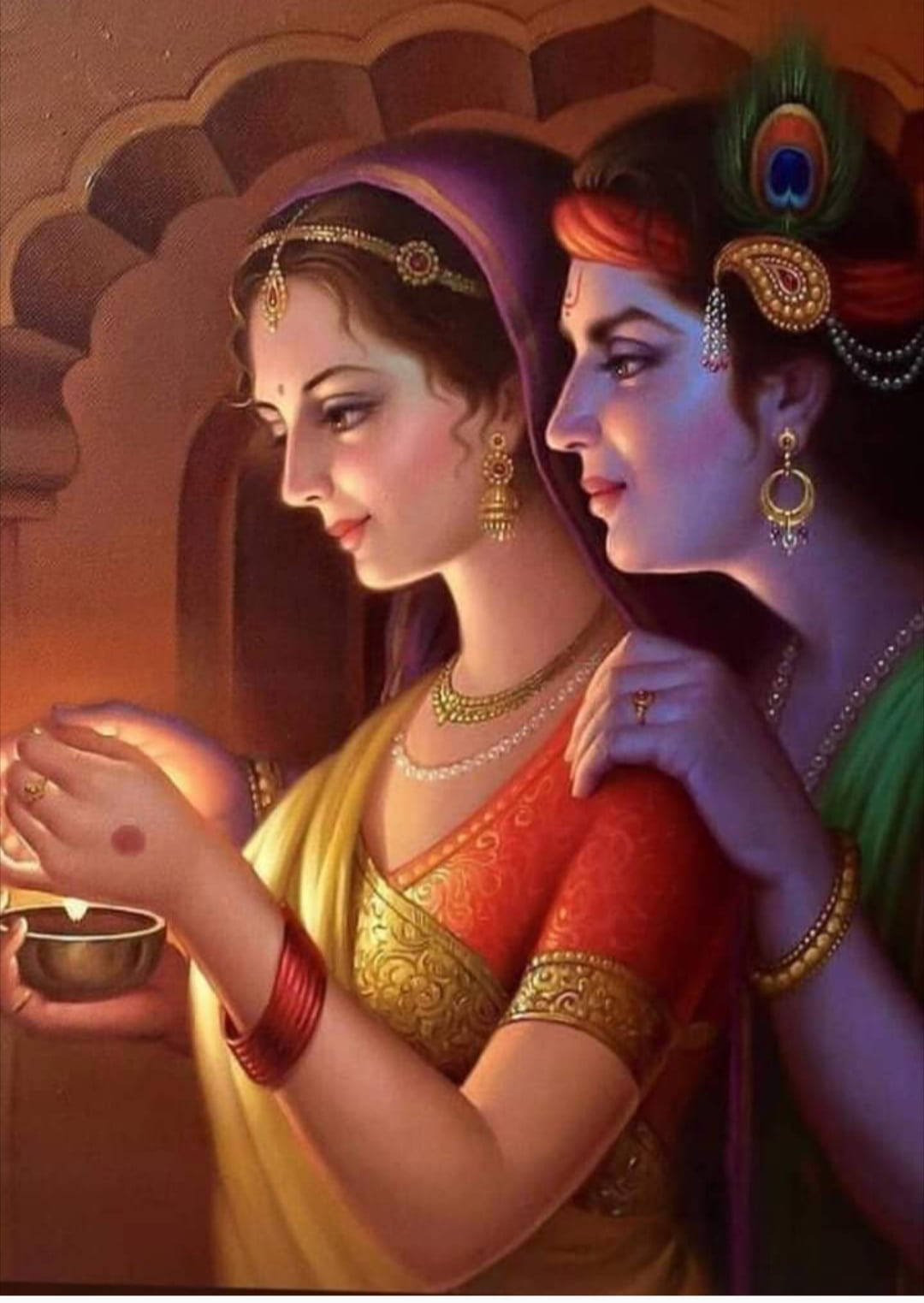 krishna iPhone 桌布 壁紙 — 兩位穿著傳統服飾、優雅裝扮的印度女性，在溫暖的環境燈光下分享溫馨時刻。