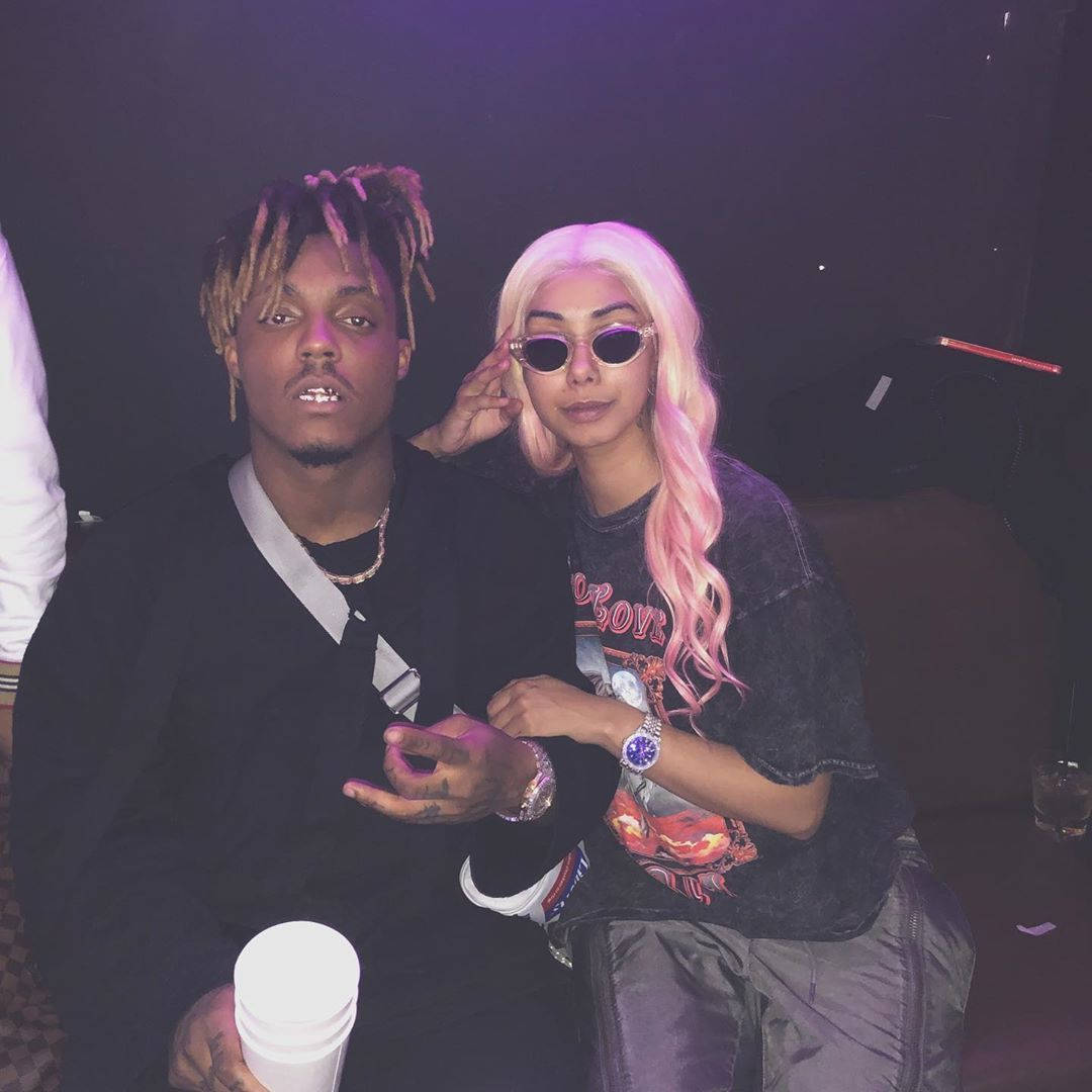 Juice Wrld And Ally 桌布 壁紙 — 兩位穿著時尚的人士在燈光昏暗、帶有紫色燈光和鮮豔粉紅色頭髮點綴的俱樂部中緊密地擺姿勢。