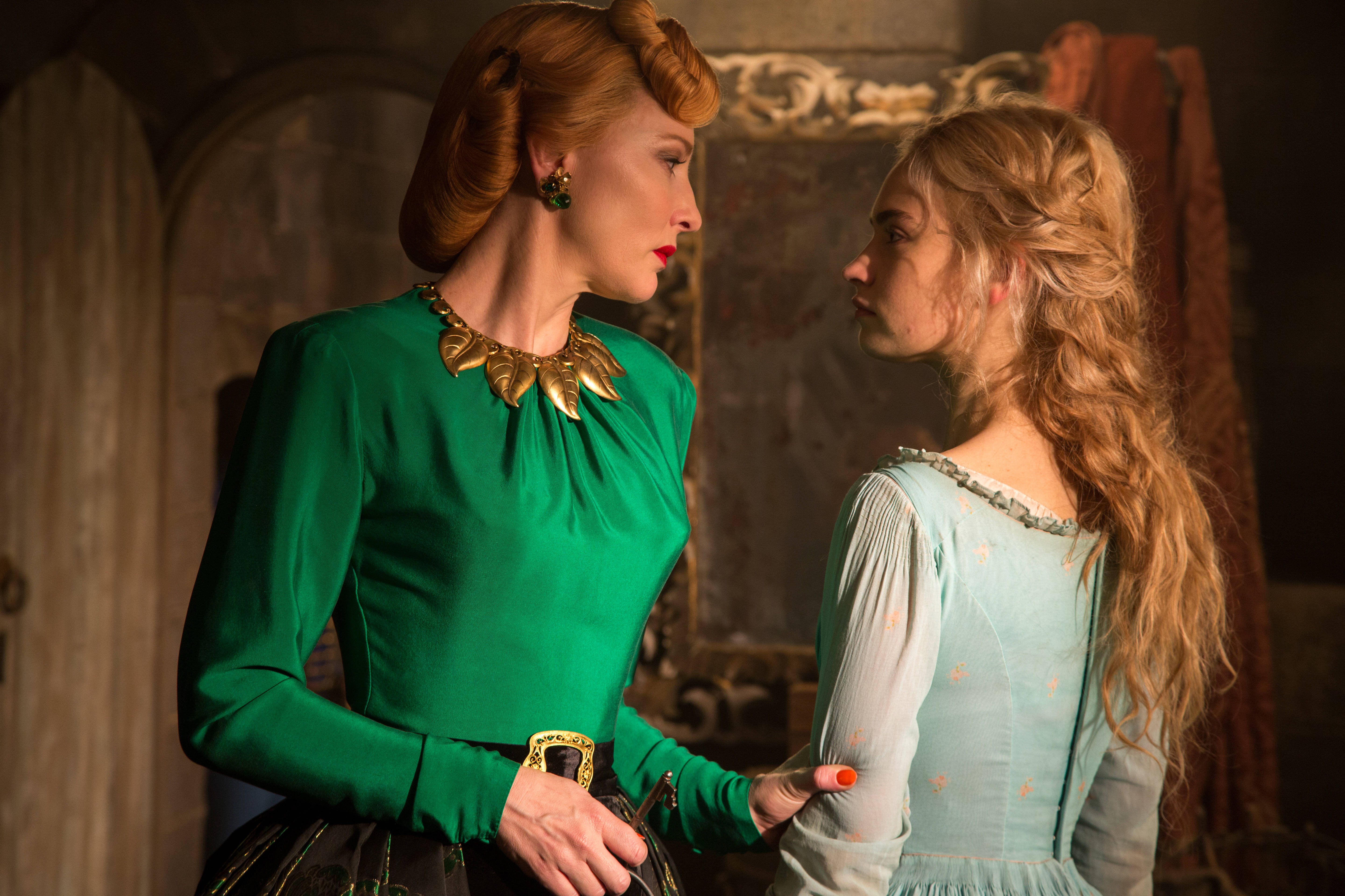 Cate 桌布 壁紙 — 兩位穿著華麗時代服裝的女性在光線昏暗的石室中，以戲劇性的燈光面對面。