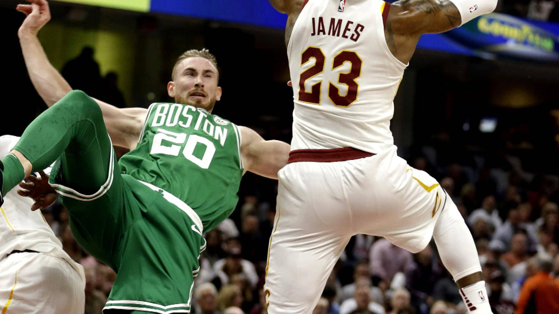gordon hayward 桌布 壁紙 — 兩位籃球運動員在激烈比賽中躍起空中，一位身穿綠色波士頓球衣，另一位身穿白色克里夫蘭球衣，號碼23。