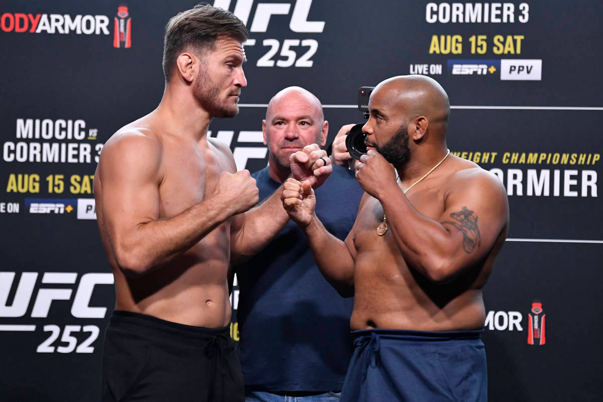 UFC 桌布 壁紙 — 兩位肌肉發達的UFC拳手在稱重活動中鎖拳進行緊張的賽前對視。