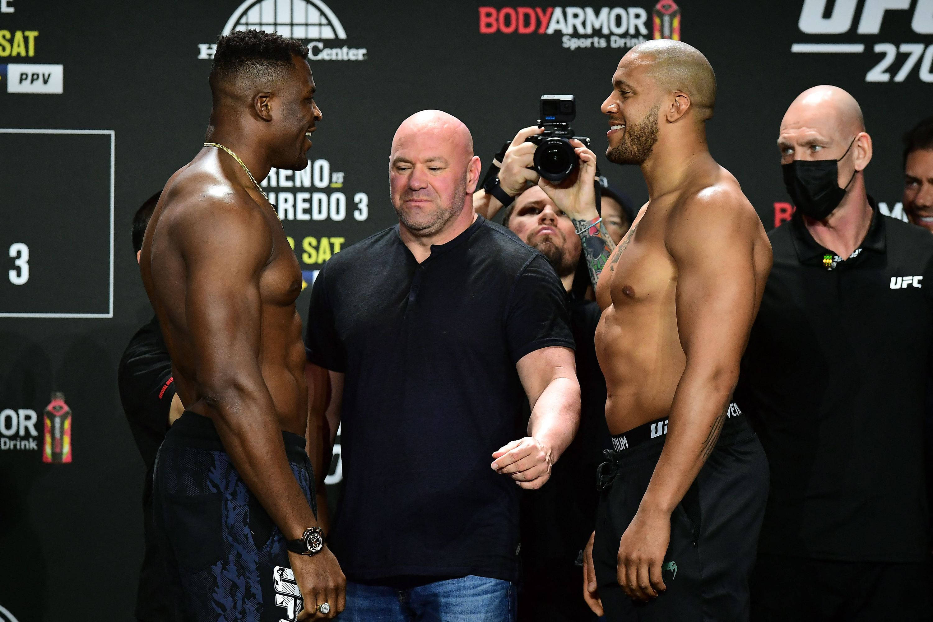 MMA 桌布 壁紙 — 兩位肌肉發達的UFC拳手在稱重活動中對峙，裁判站在他們之間，攝影師捕捉這一刻。