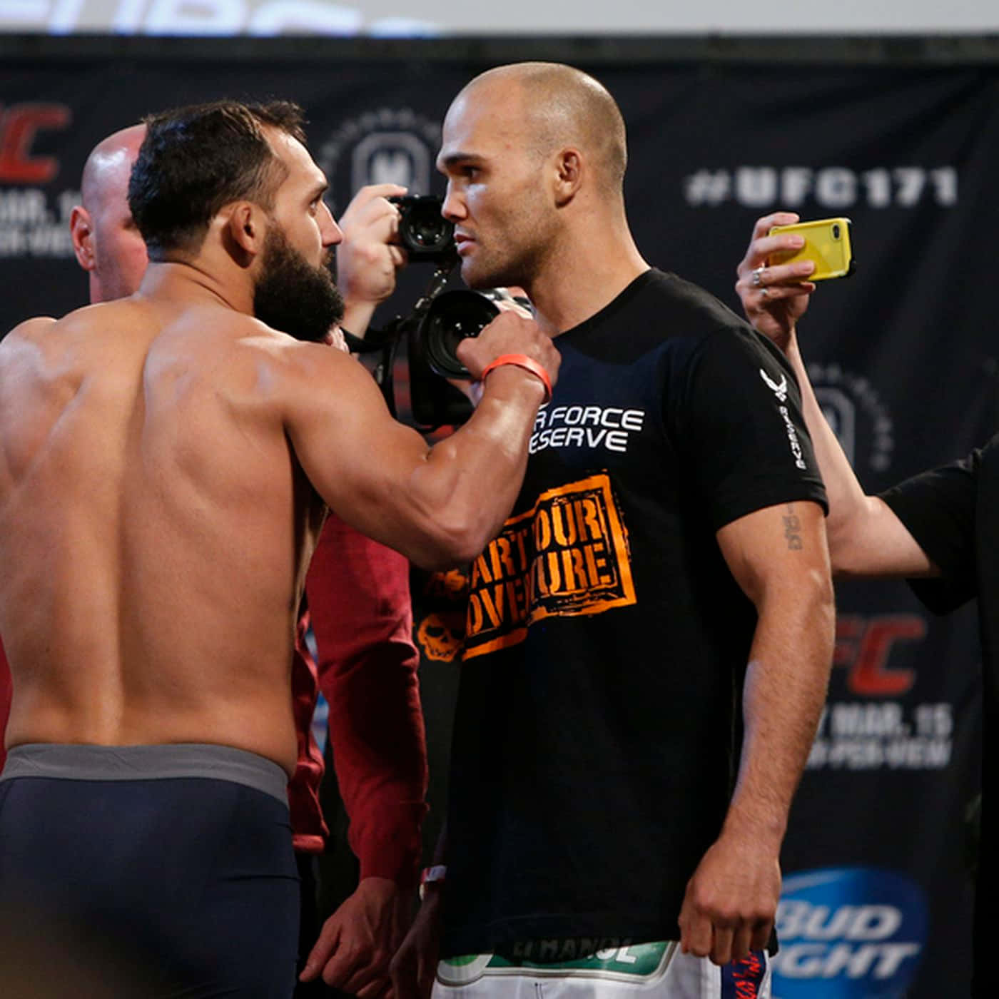 UFC 桌布 壁紙 — 兩位肌肉發達的UFC拳手在閃光燈環繞下，於過磅時激烈對峙。
