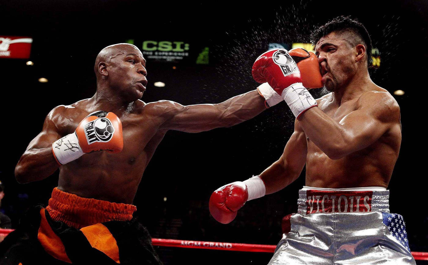 Boxing 桌布 壁紙 — 兩位肌肉發達的拳擊手在擂台上戲劇性地碰撞，汗水飛濺，其中一人打出強力一拳。