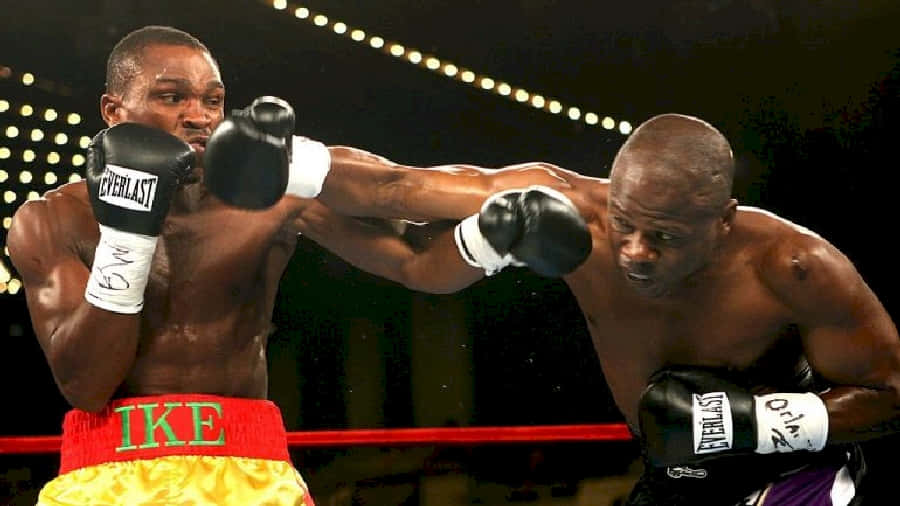 Boxing 桌布 壁紙 — 兩位肌肉發達的拳擊手在緊張的擂台上碰撞，汗水飛濺，背後燈光閃耀。