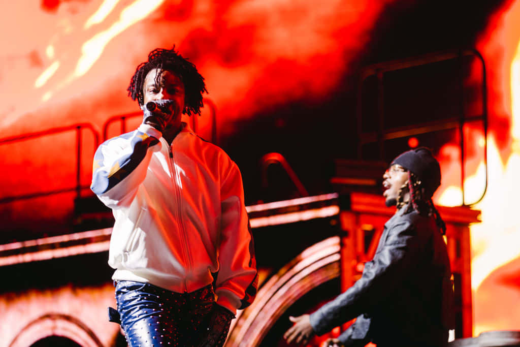 21 Savage 桌布 壁紙 — 兩位表演者為一個充滿火紅燈光和煙霧的音樂會舞台注入活力。