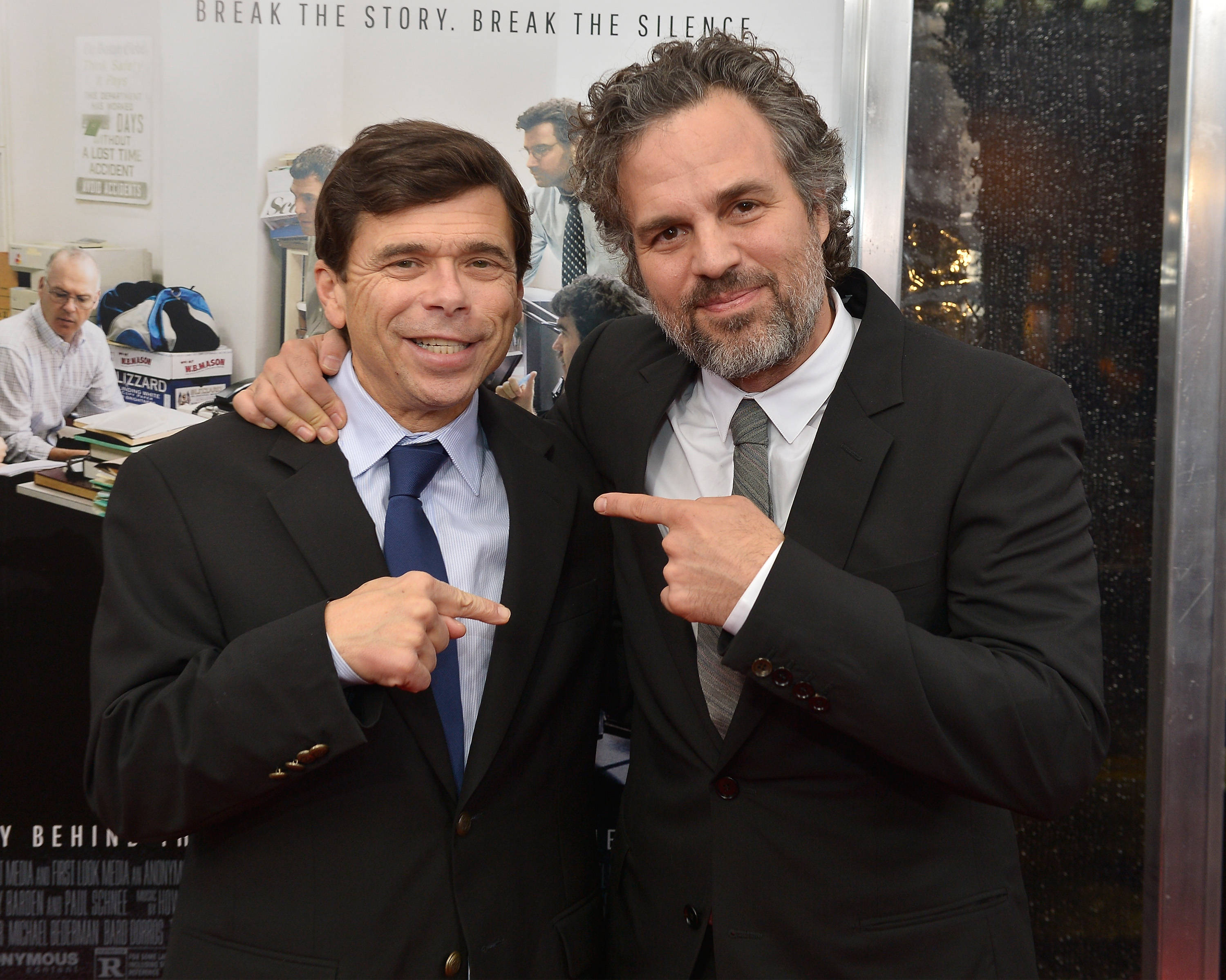 Spotlight 桌布 壁紙 — 兩位西裝筆挺的男士在電影首映會上微笑擺姿勢，其中一人指向另一人。