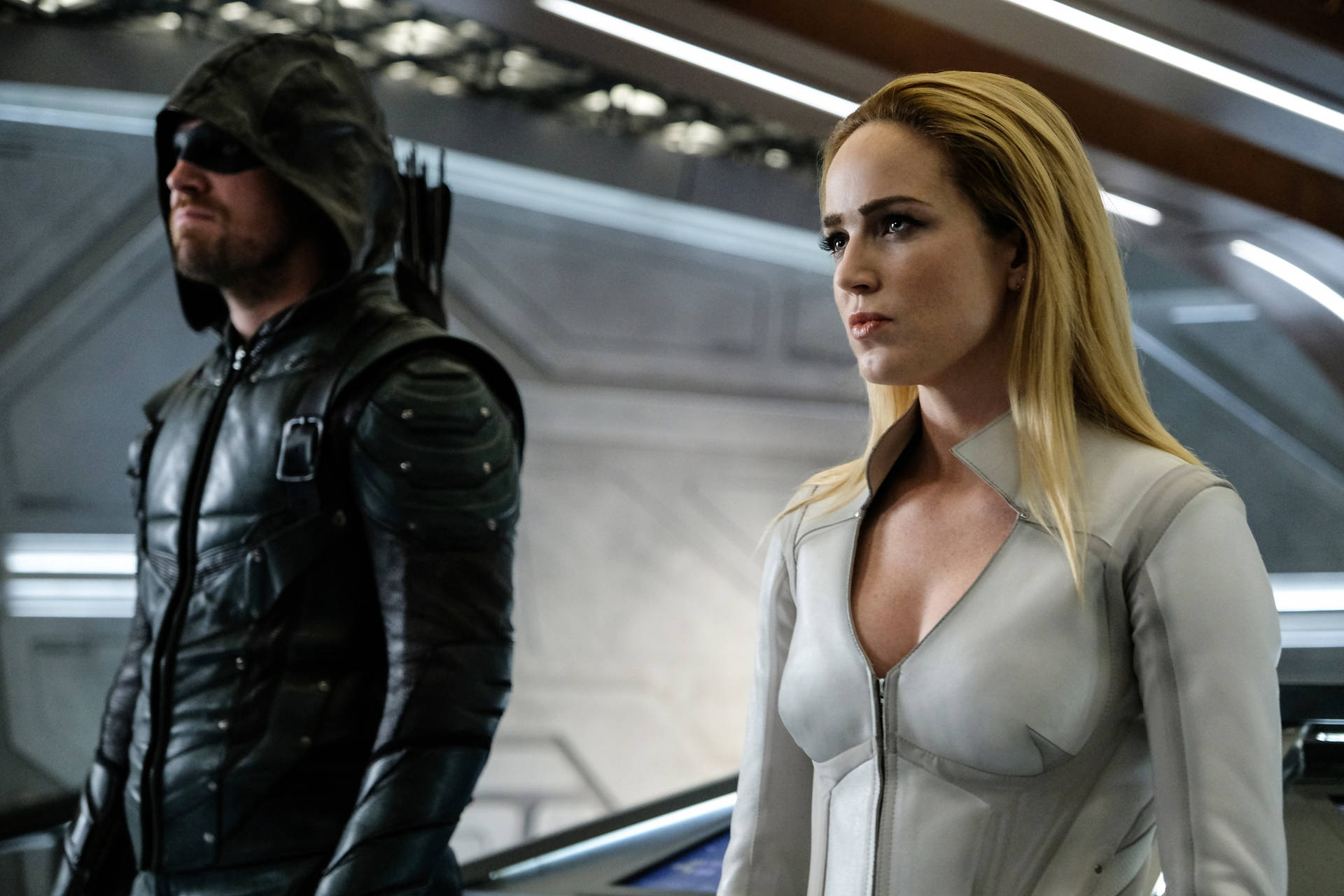 兩位身穿未來風格盔甲的超級英雄站在太空船走廊上。 — Caity Lotz 動圖 壁紙