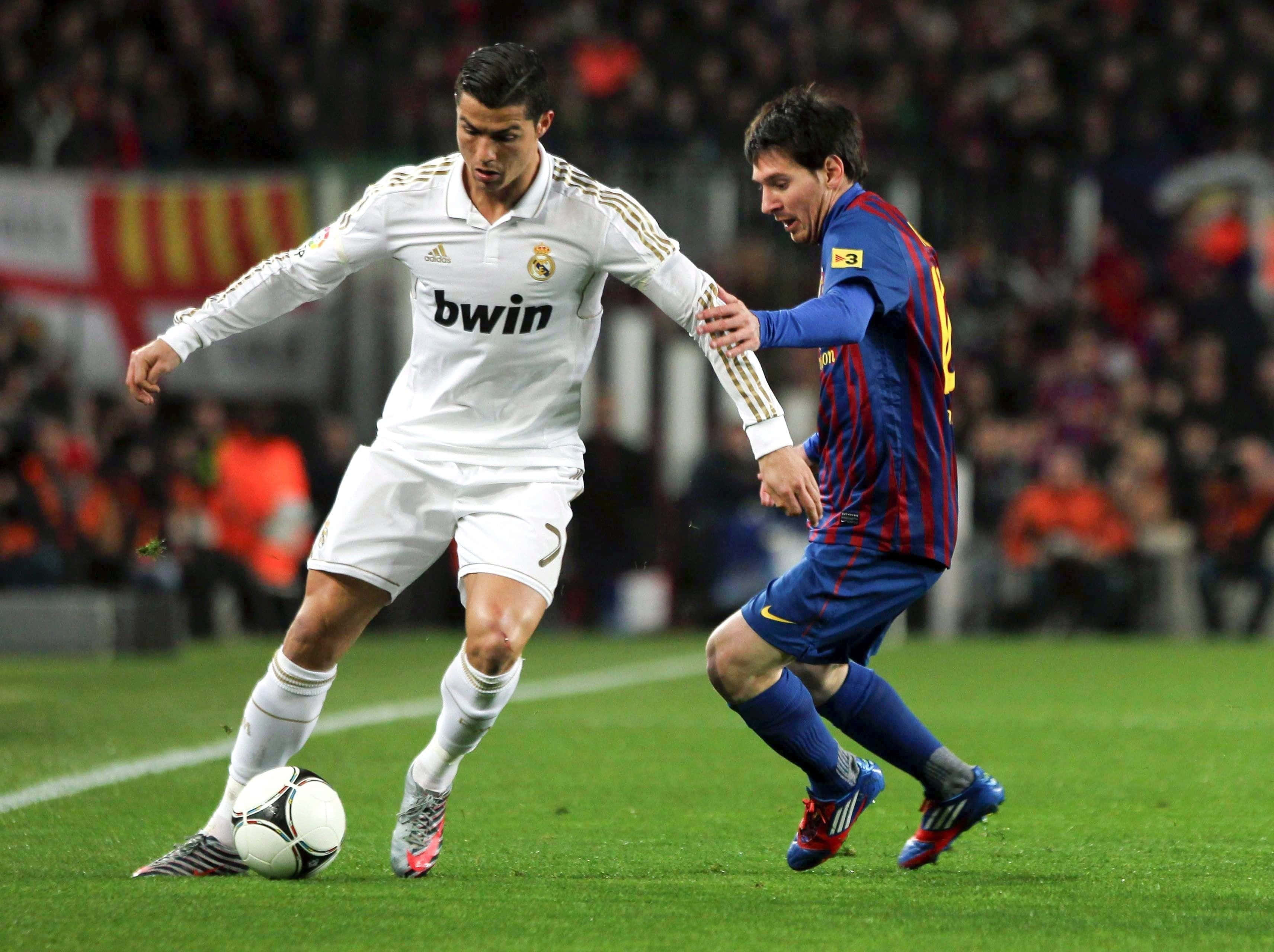 Cristiano Ronaldo 足球 桌布 壁紙 — 兩位足球明星在球場燈光下，於一場高風險比賽中激烈爭奪控球權。