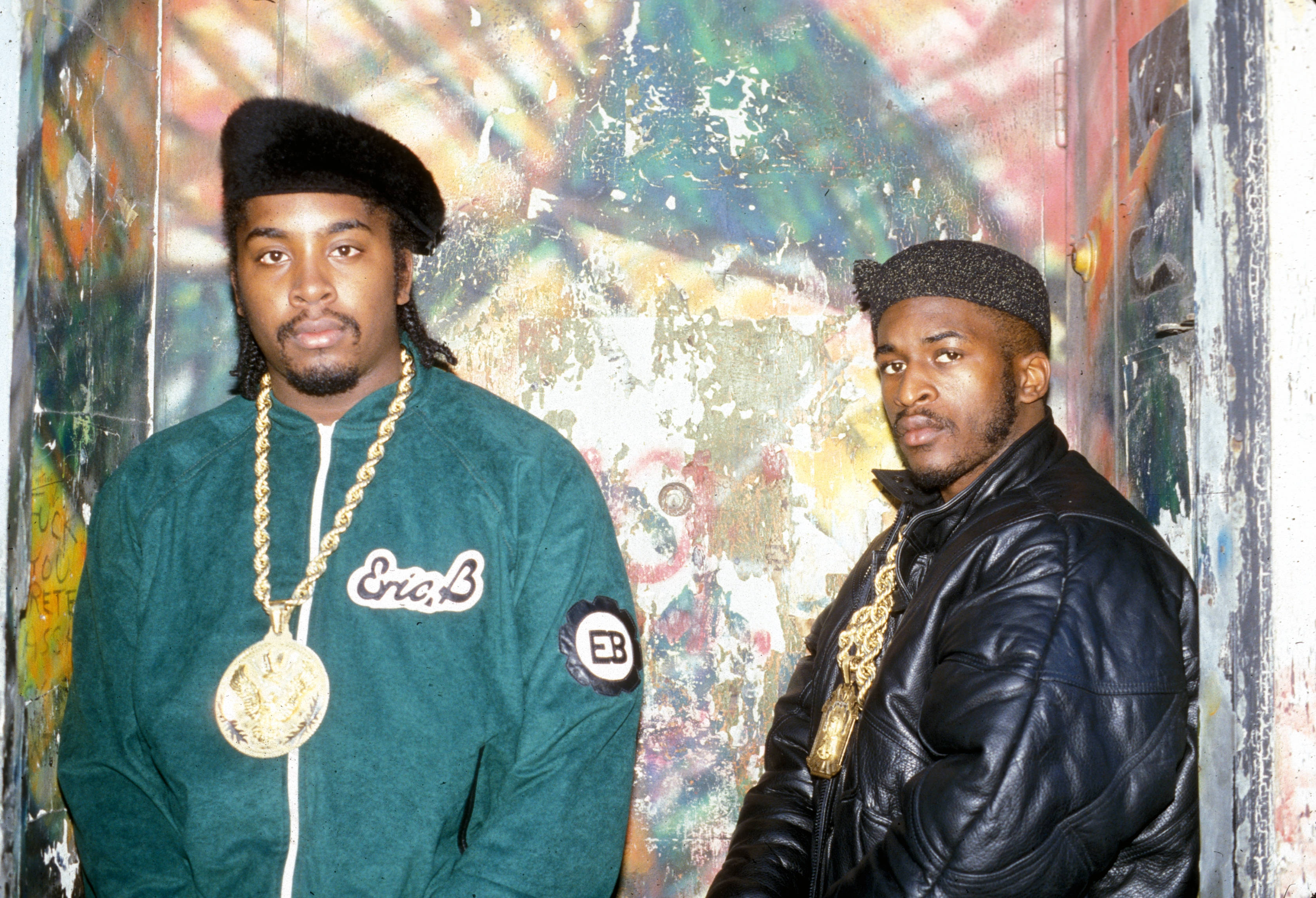 Rappers 桌布 壁紙 — 兩位身穿90年代街頭服飾的男士，在充滿活力的塗鴉牆前自信地擺姿勢。