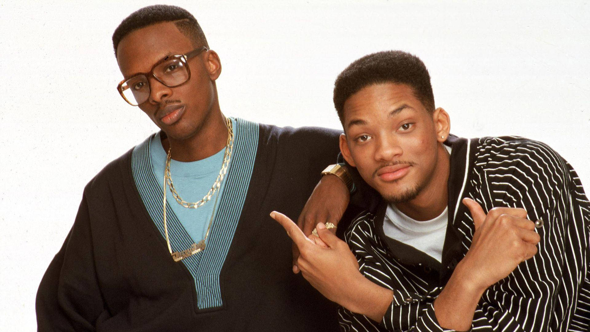 fresh prince 桌布 壁紙 — 兩位身穿90年代街頭服飾的男士在純白背景前自信地擺姿勢，配以大膽的配飾和富有表現力的手勢。