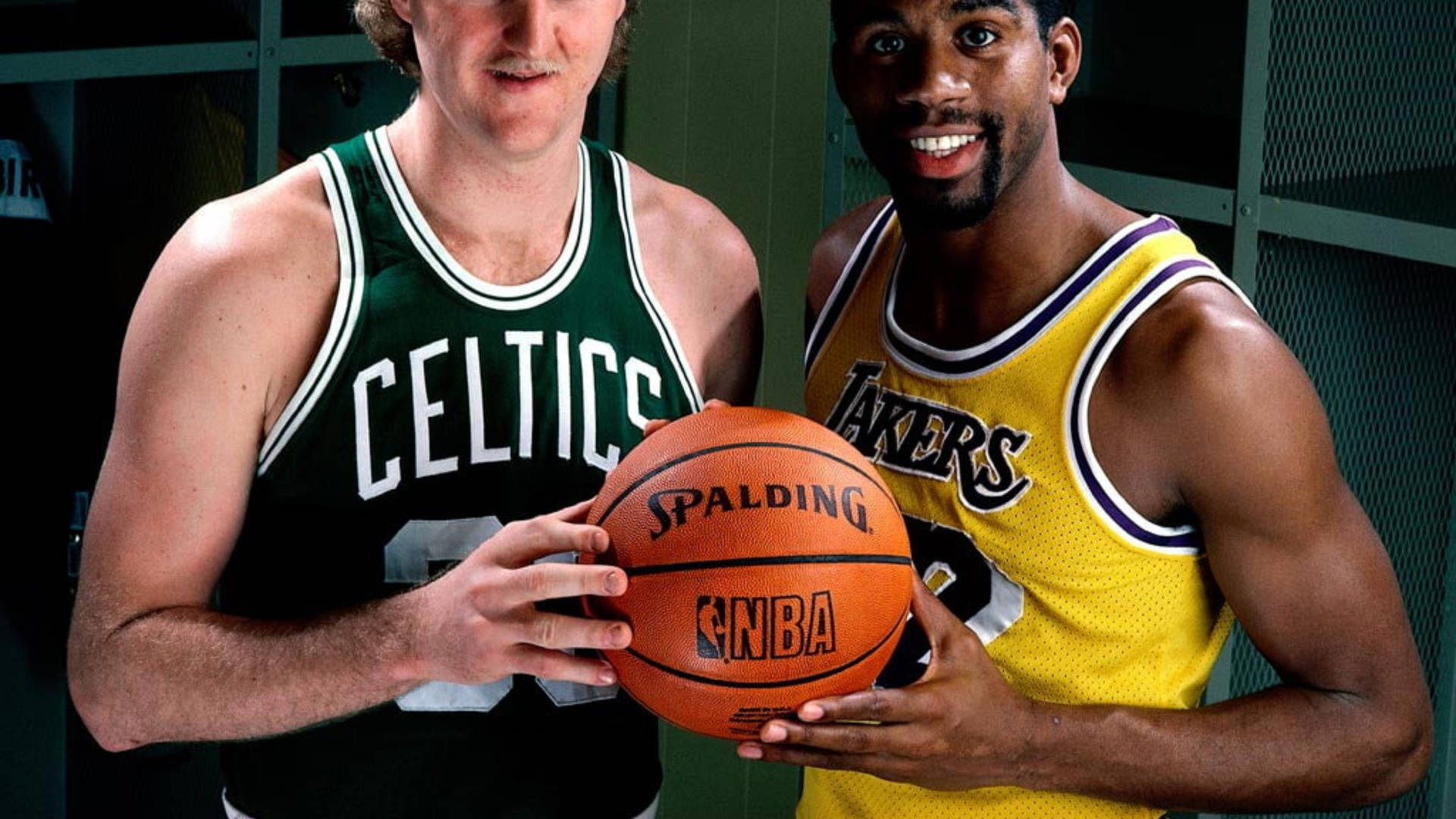 兩位身穿球隊球衣的籃球傳奇手持Spalding NBA籃球。