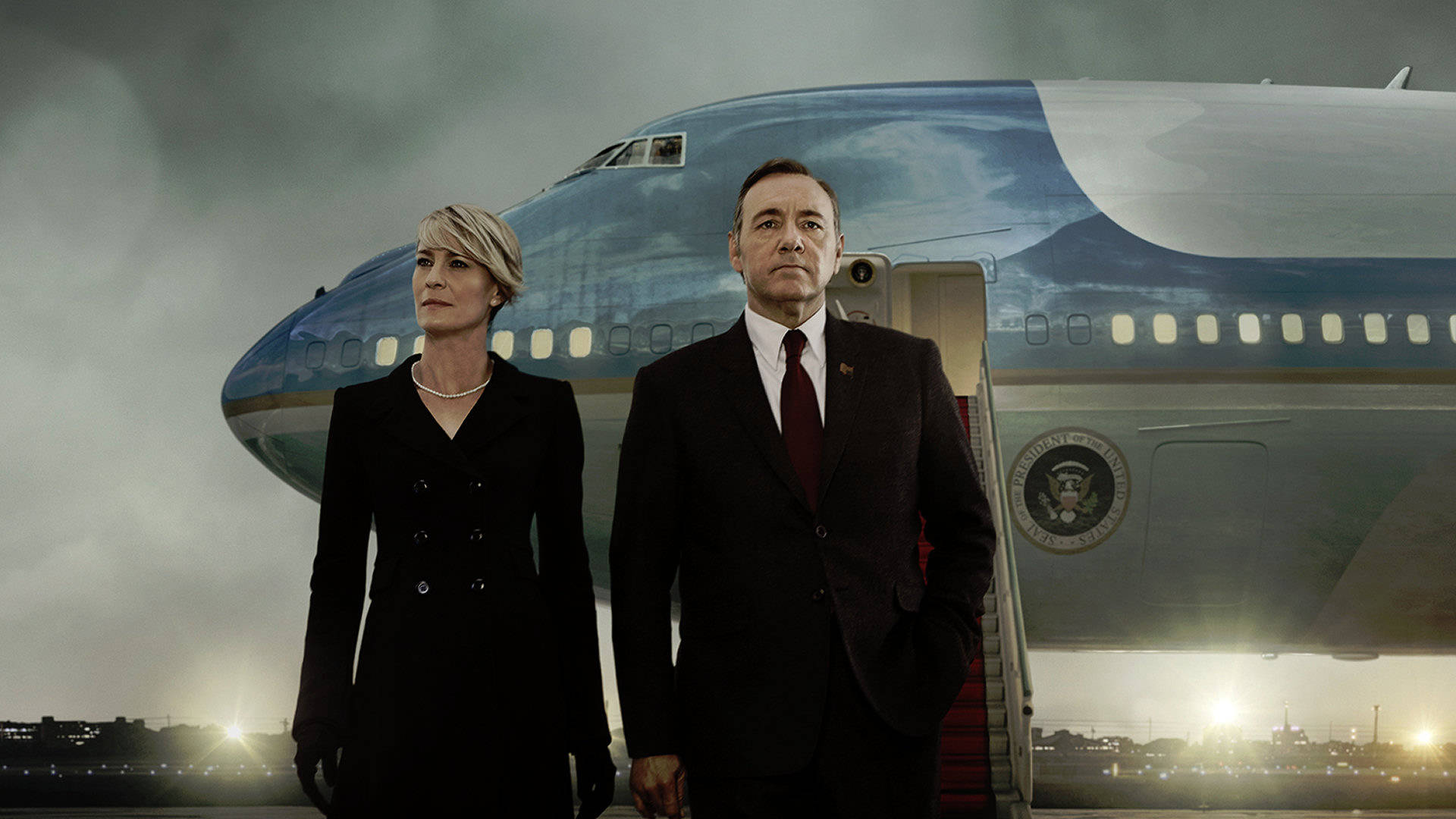 kevin spacey 桌布 壁紙 — 兩位身穿正裝的人物莊嚴地站在總統專機前，背景是暴風雨的天空，下方城市燈光閃爍。