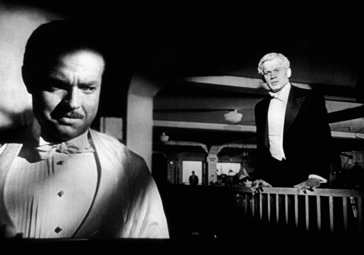 Citizen Kane 桌布 壁紙 — 兩位身穿燕尾服的男士站在光線昏暗的房間中，戲劇性的明暗對比光線投下深邃陰影。