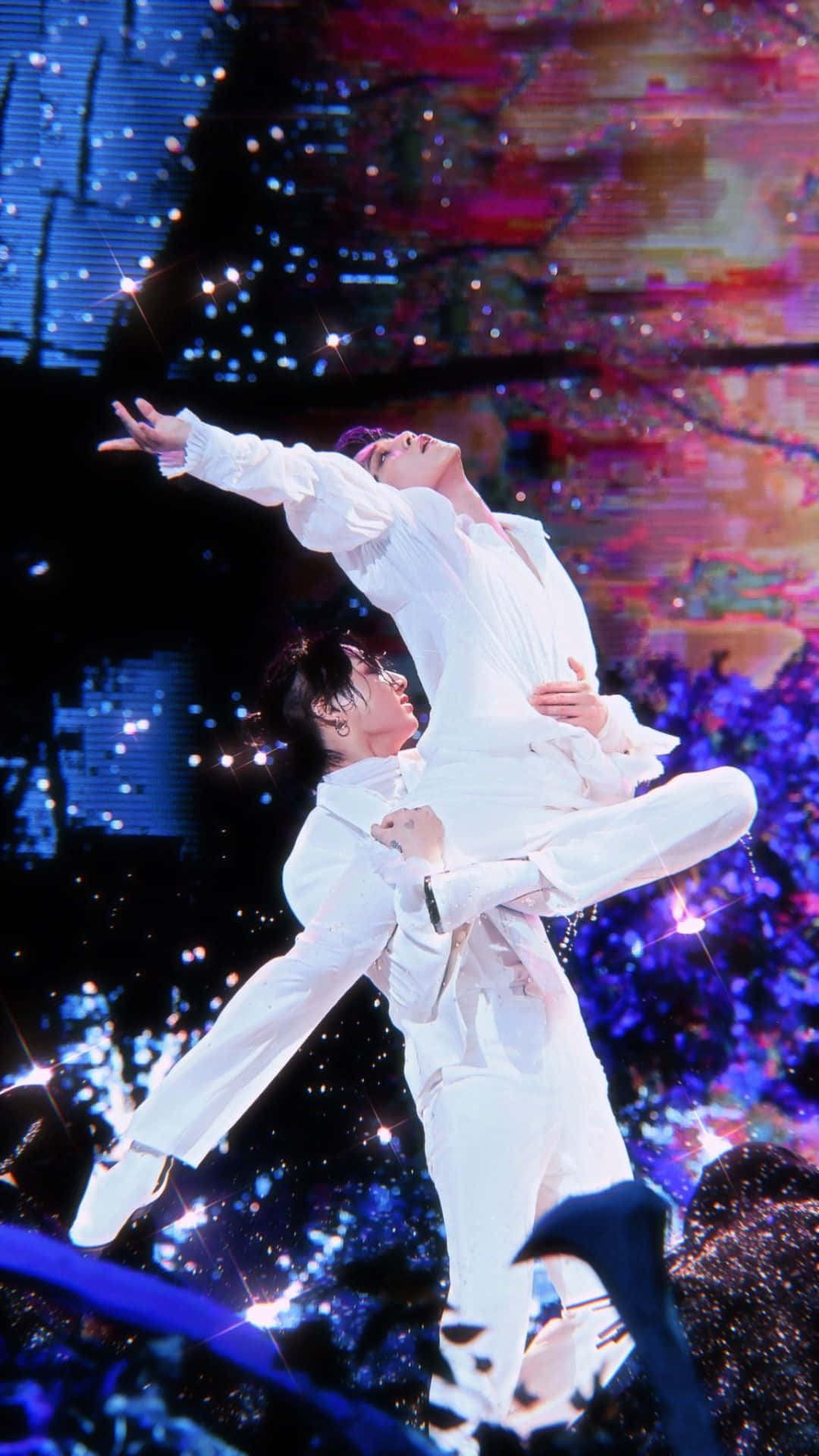 Bts Performance 桌布 壁紙 — 兩位身穿白色西裝的舞者在閃爍的舞台燈光下，搭配充滿活力的數位背景，表演戲劇性的托舉動作。