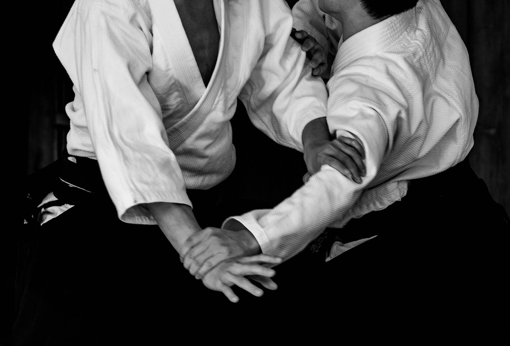 martial arts 桌布 壁紙 — 兩位身穿白色道服的武術家在黑白特寫中激烈纏鬥。