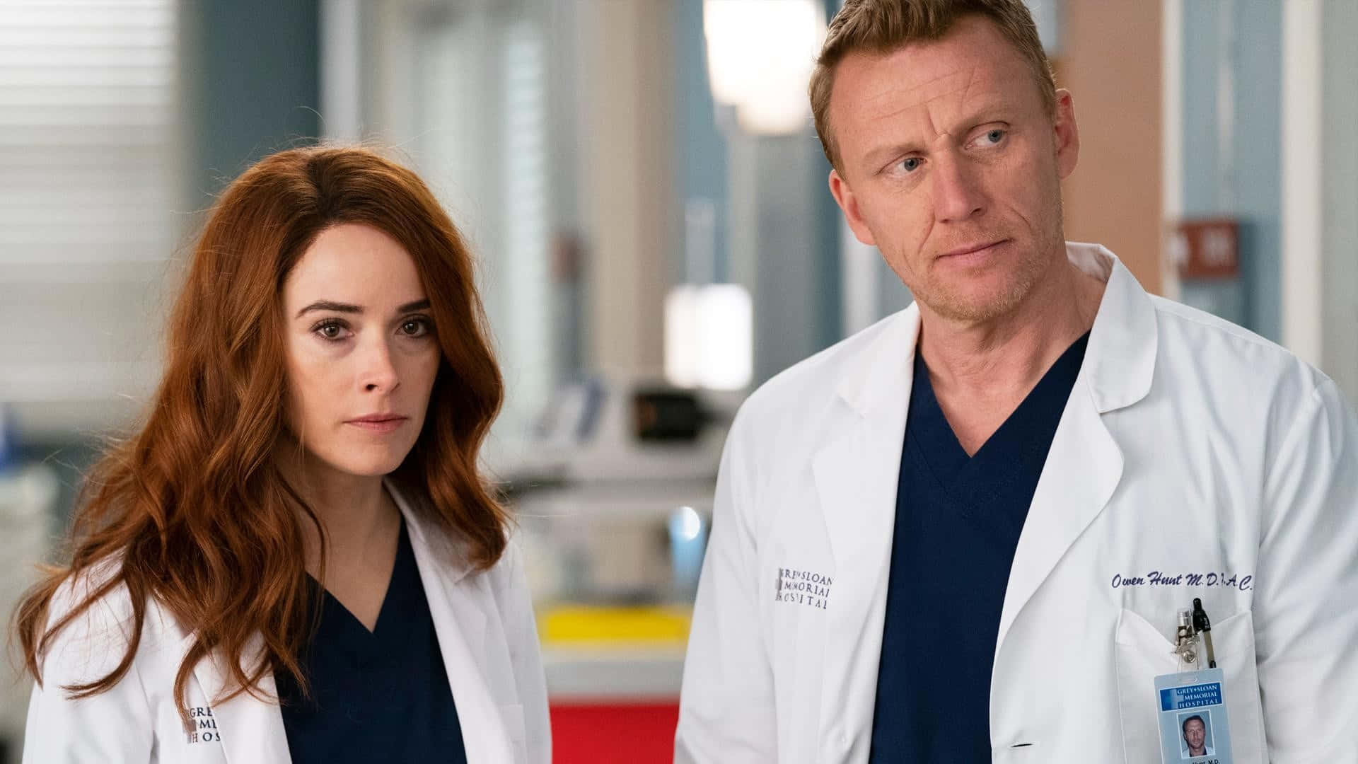 Grey's Anatomy 桌布 壁紙 — 兩位身穿白袍的醫生站在醫院走廊，表情嚴肅。