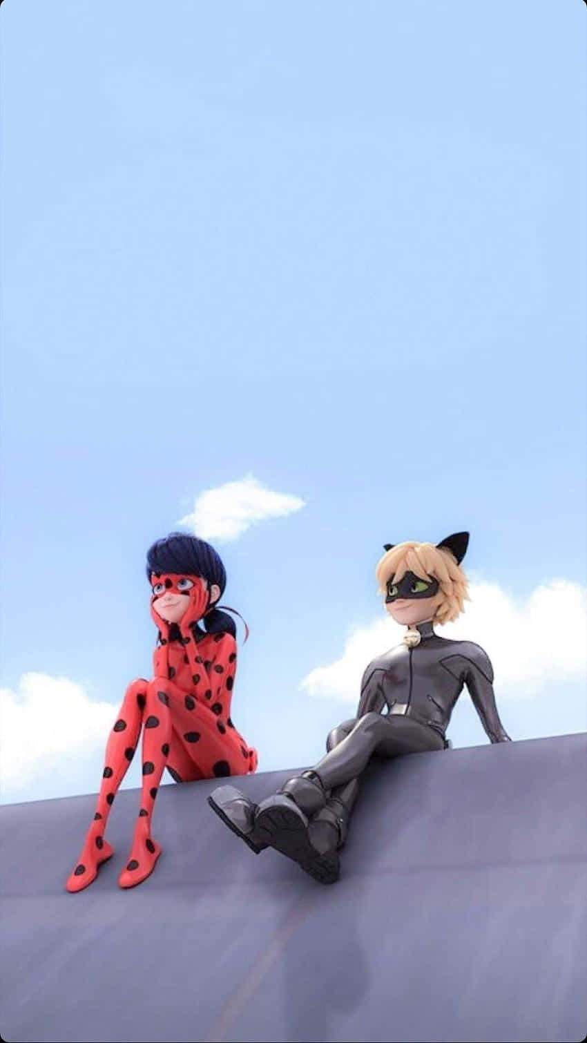 Marinette And Adrien 桌布 壁紙 — 兩位身穿紅色和黑色套裝的動畫超級女英雄，在晴朗藍天和蓬鬆雲朵下並肩坐在屋頂上。