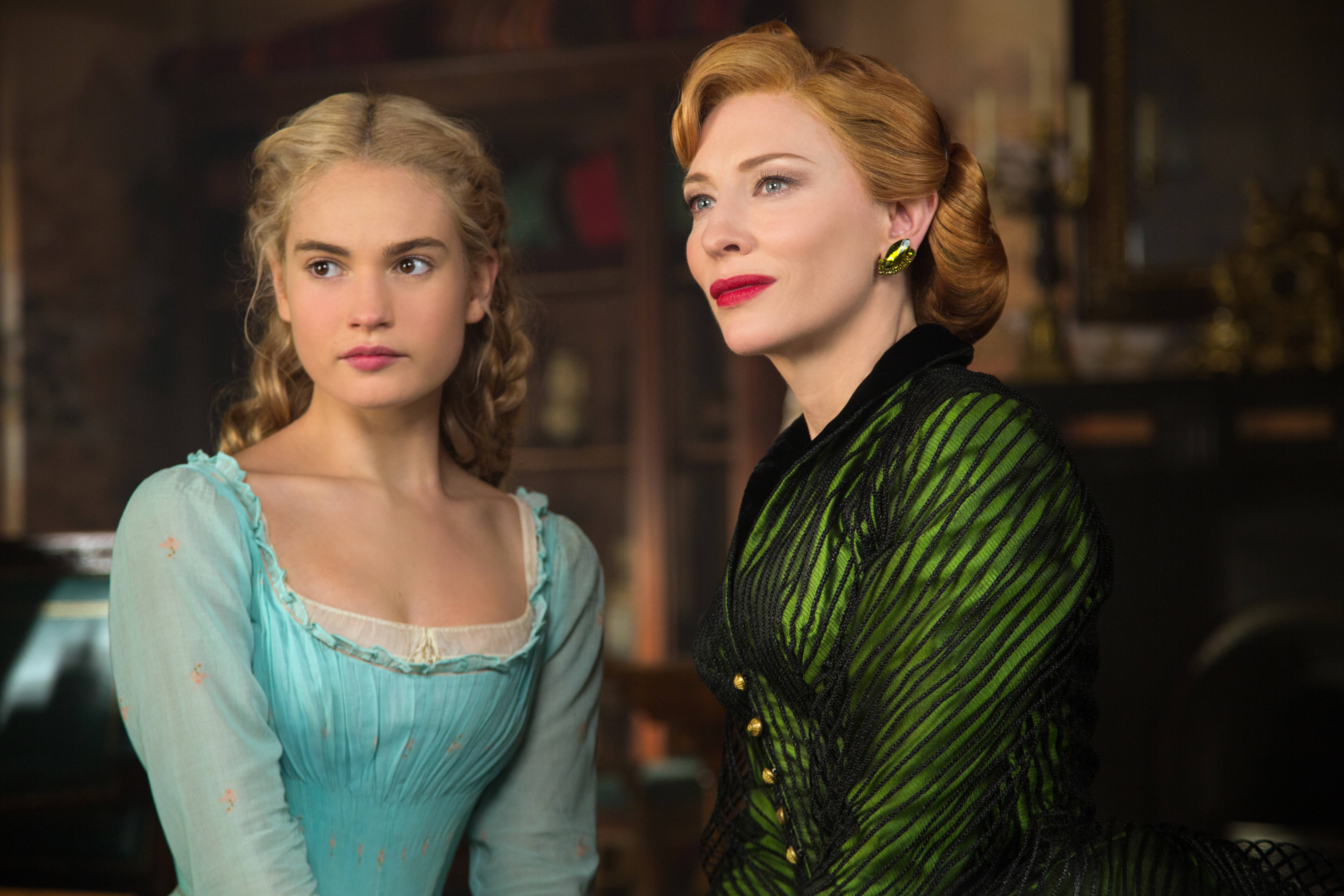 Cate 桌布 壁紙 — 兩位身穿華麗時代服裝的女性站在光線昏暗的復古房間中，房間內有豐富的木製家具和溫暖的燭光氛圍。