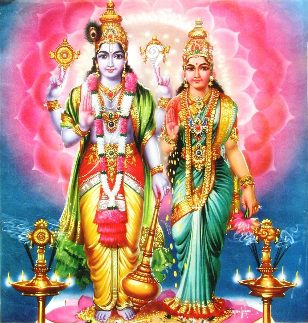 Indian 桌布 壁紙 — 兩位身穿華麗金色服飾的神聖人物，站在燦爛的粉紅蓮花背景前，腳邊有發光的油燈。