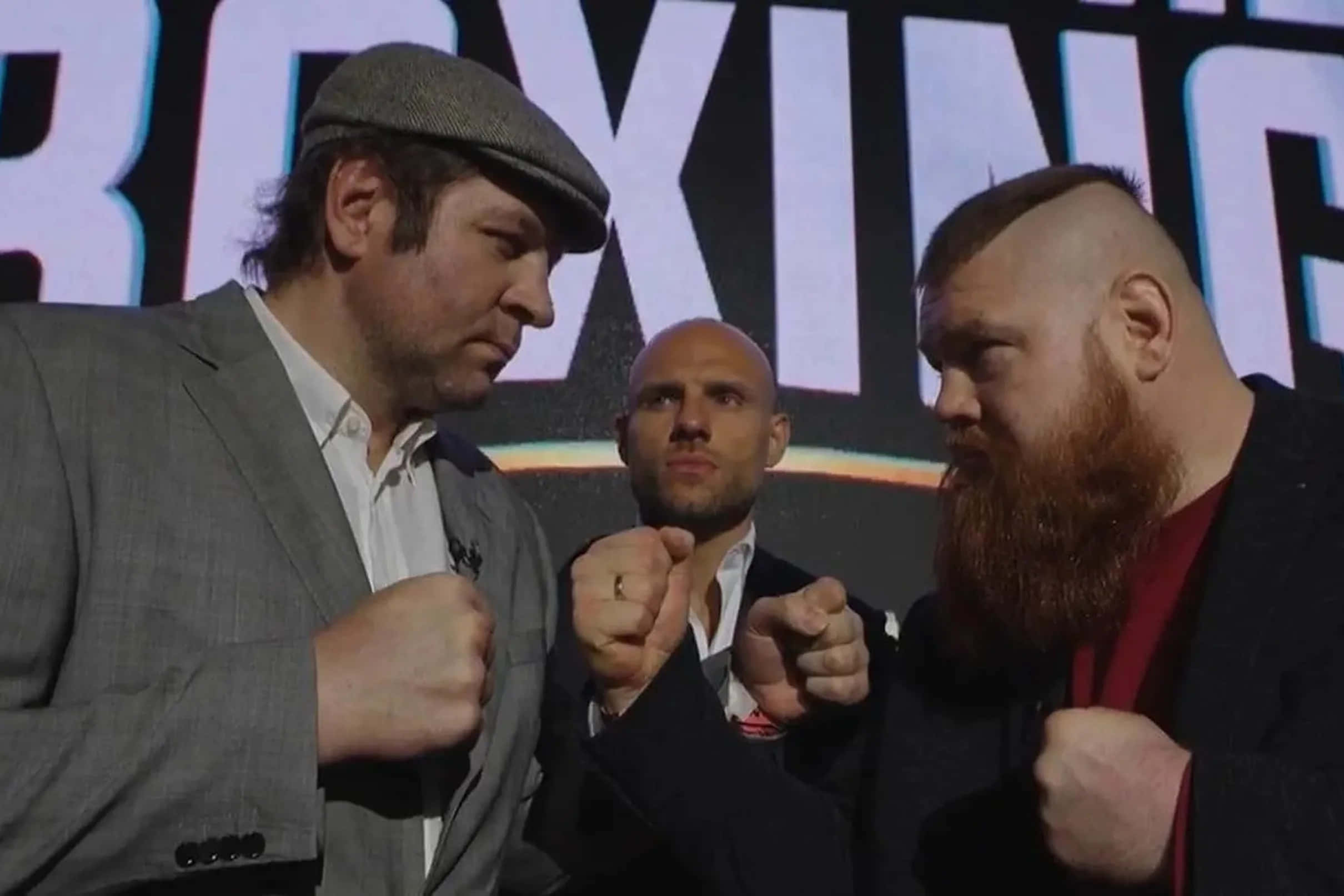 MMA 桌布 壁紙 — 兩位身穿西裝的拳擊手在拳擊賽事的明亮燈光下握拳對峙。