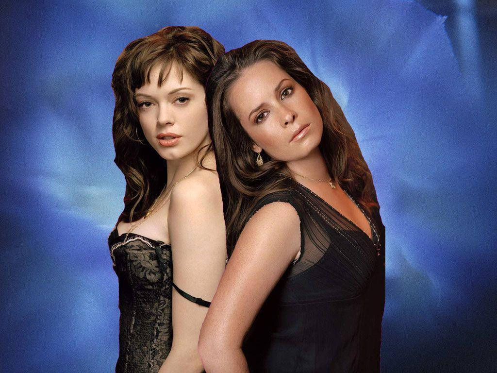 charmed 桌布 壁紙 — 兩位身穿黑色蕾絲和透視裙的女性背對背擺姿勢，背景是旋轉的藍色工作室背景。