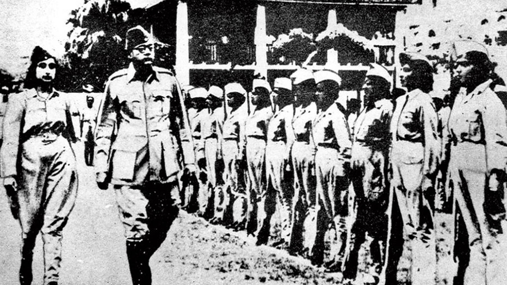 Indian 桌布 壁紙 — 兩位軍官在戶外走過一排穿著制服、立正站著的士兵的黑白歷史照片。