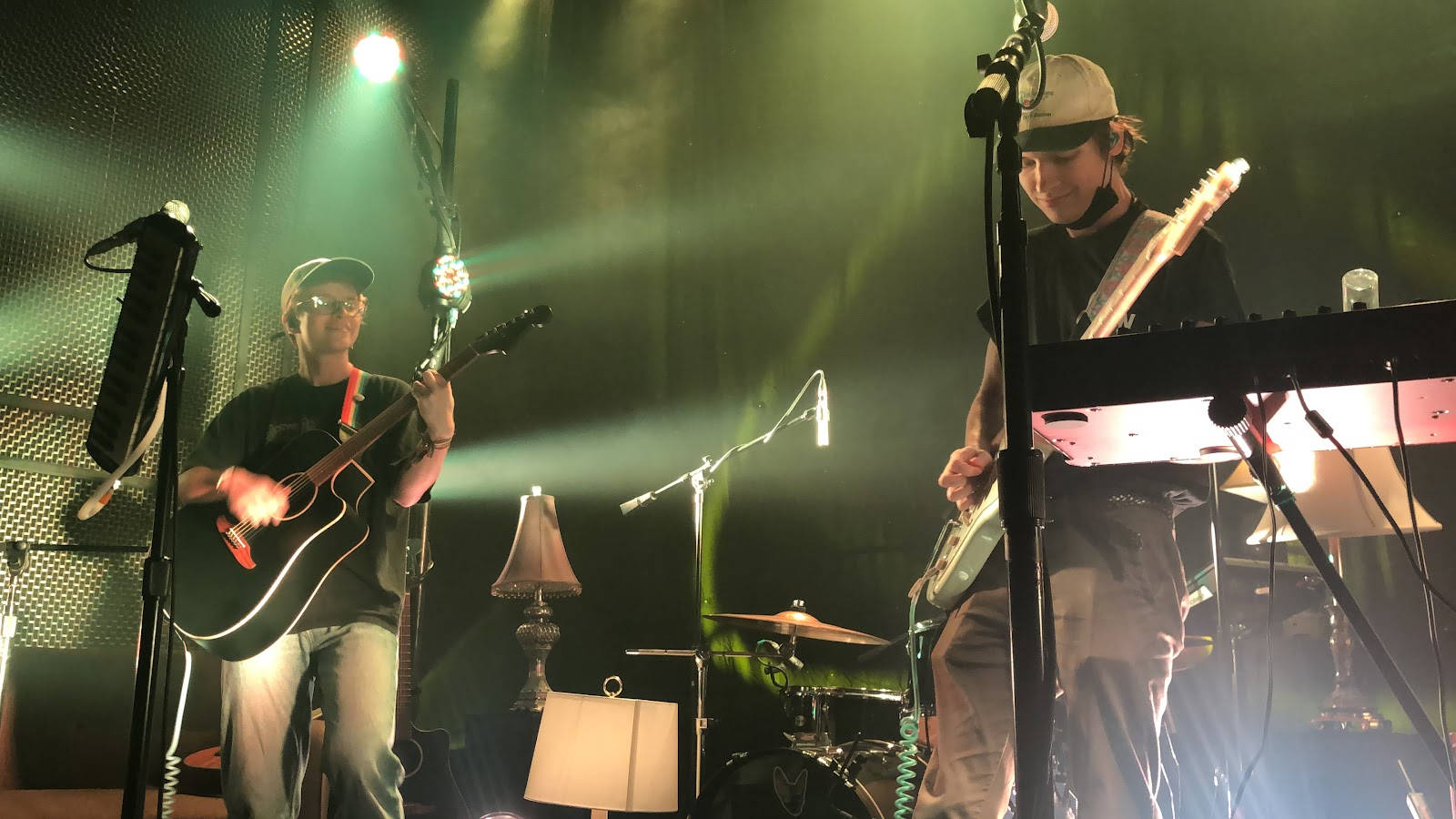 Cavetown 桌布 壁紙 — 兩位音樂家在舞台上現場表演，沐浴在綠色聚光燈下，煙霧和樂器清晰可見。
