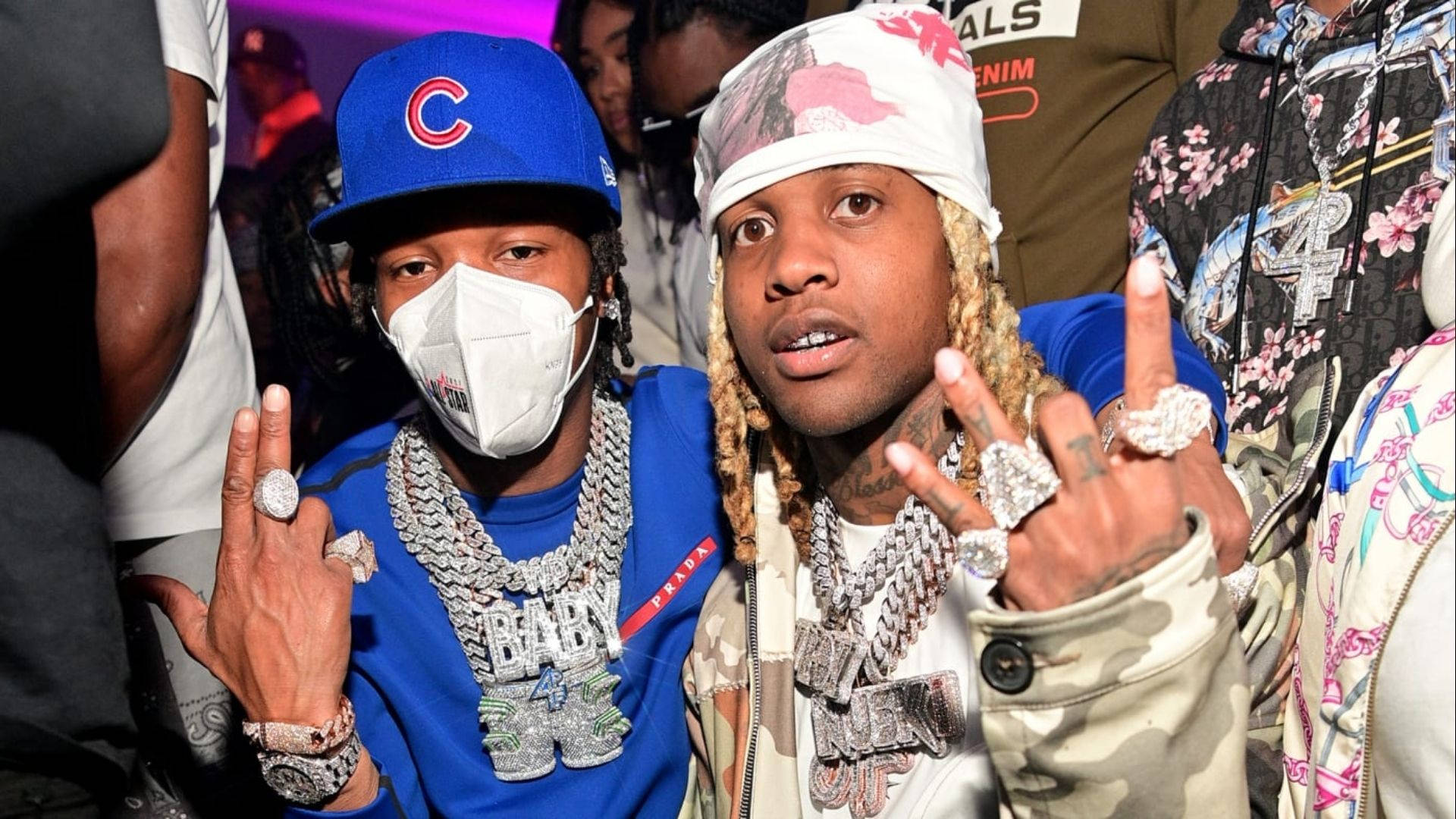 Lil Durk 桌布 壁紙 — 兩位饒舌歌手戴著閃亮珠寶和穿著大膽服裝，在燈光璀璨、人群擁擠的派對上自信擺姿勢。